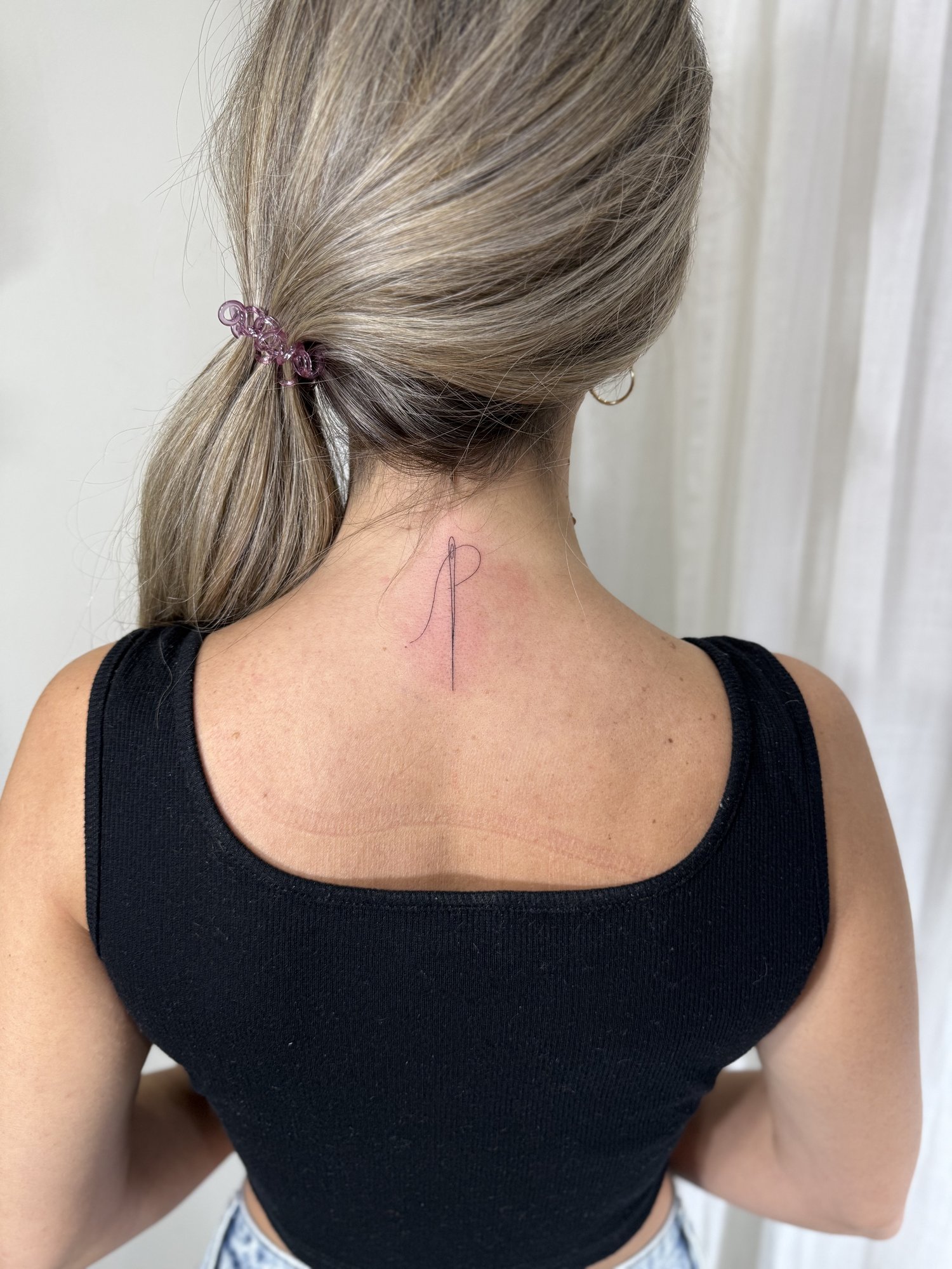 Tatuaje de aguja hilo en nuca, línea fina