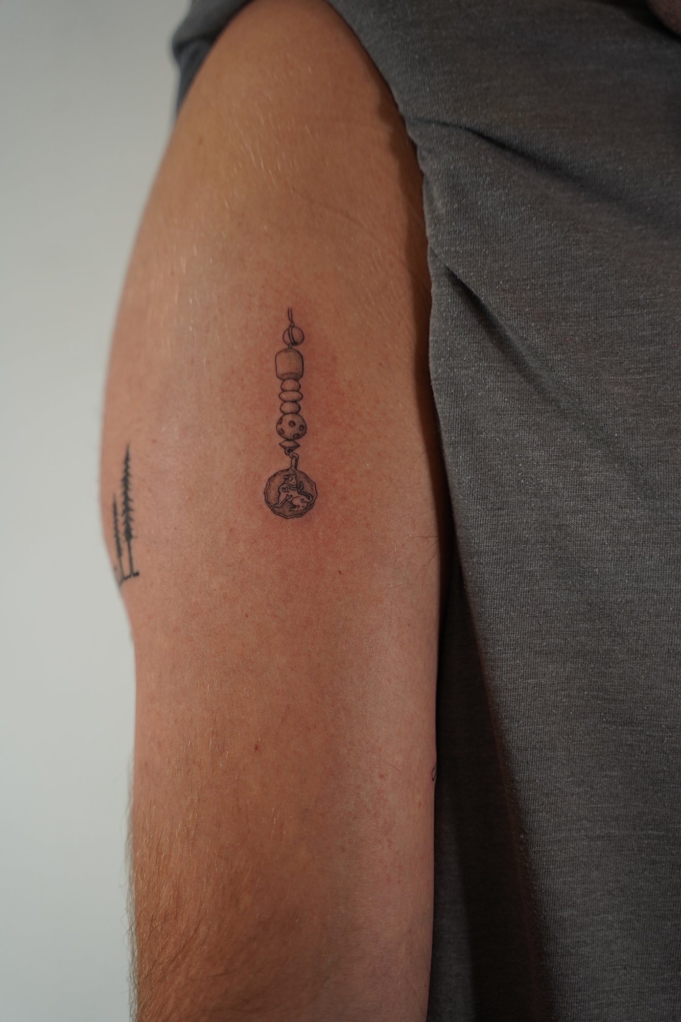Tatuaje de amuleto en zona desconocida, línea fina