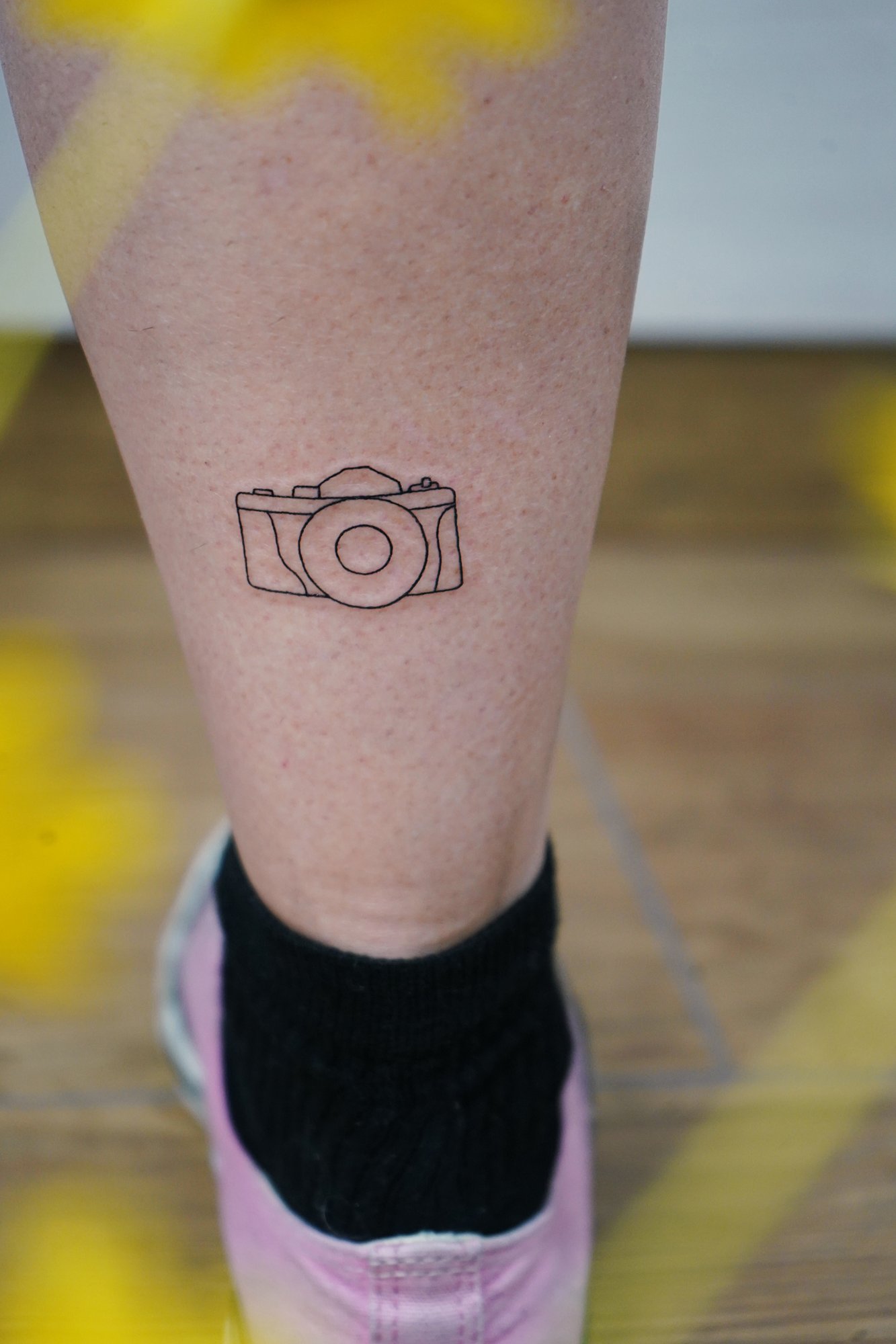 Tatuaje de camara en zona desconocida, línea fina