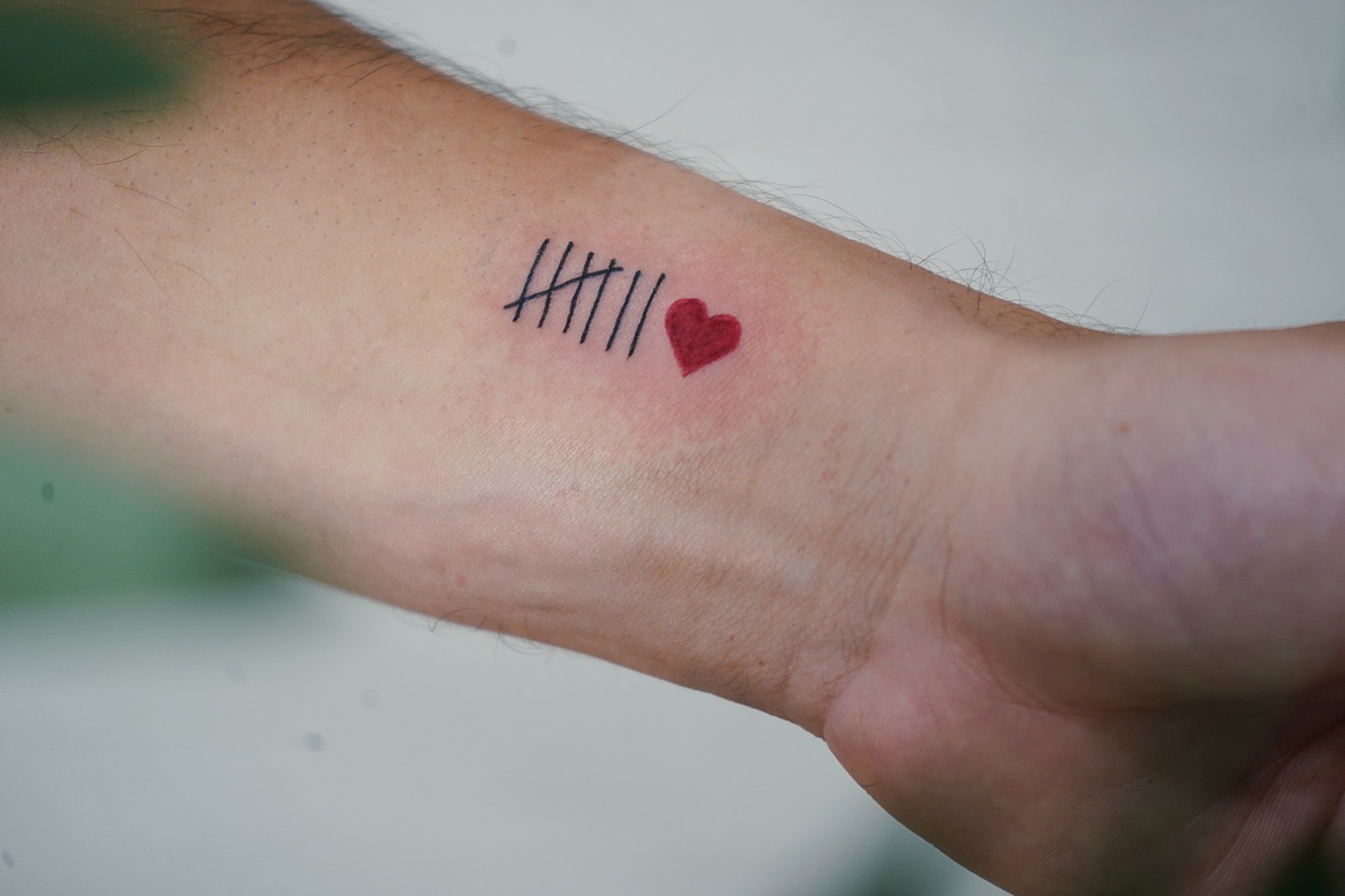 Tatuaje de carita feliz en dedo, línea fina