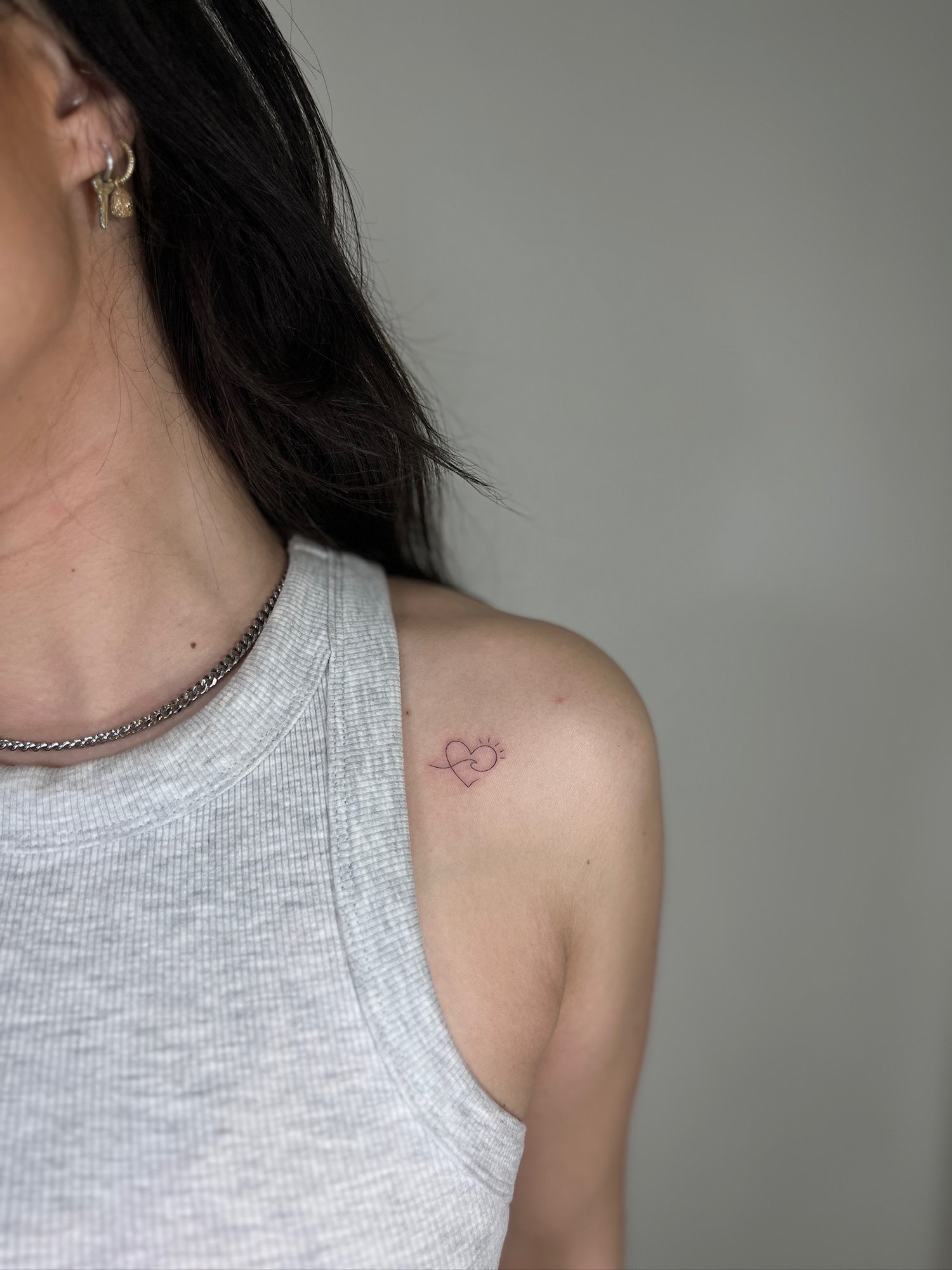 Tatuaje de corazon puzzle brillante en hombro, línea fina