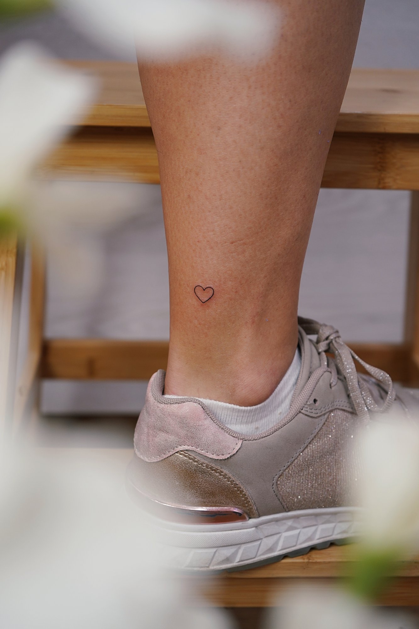 Tatuaje de corazon en tobillo, línea fina