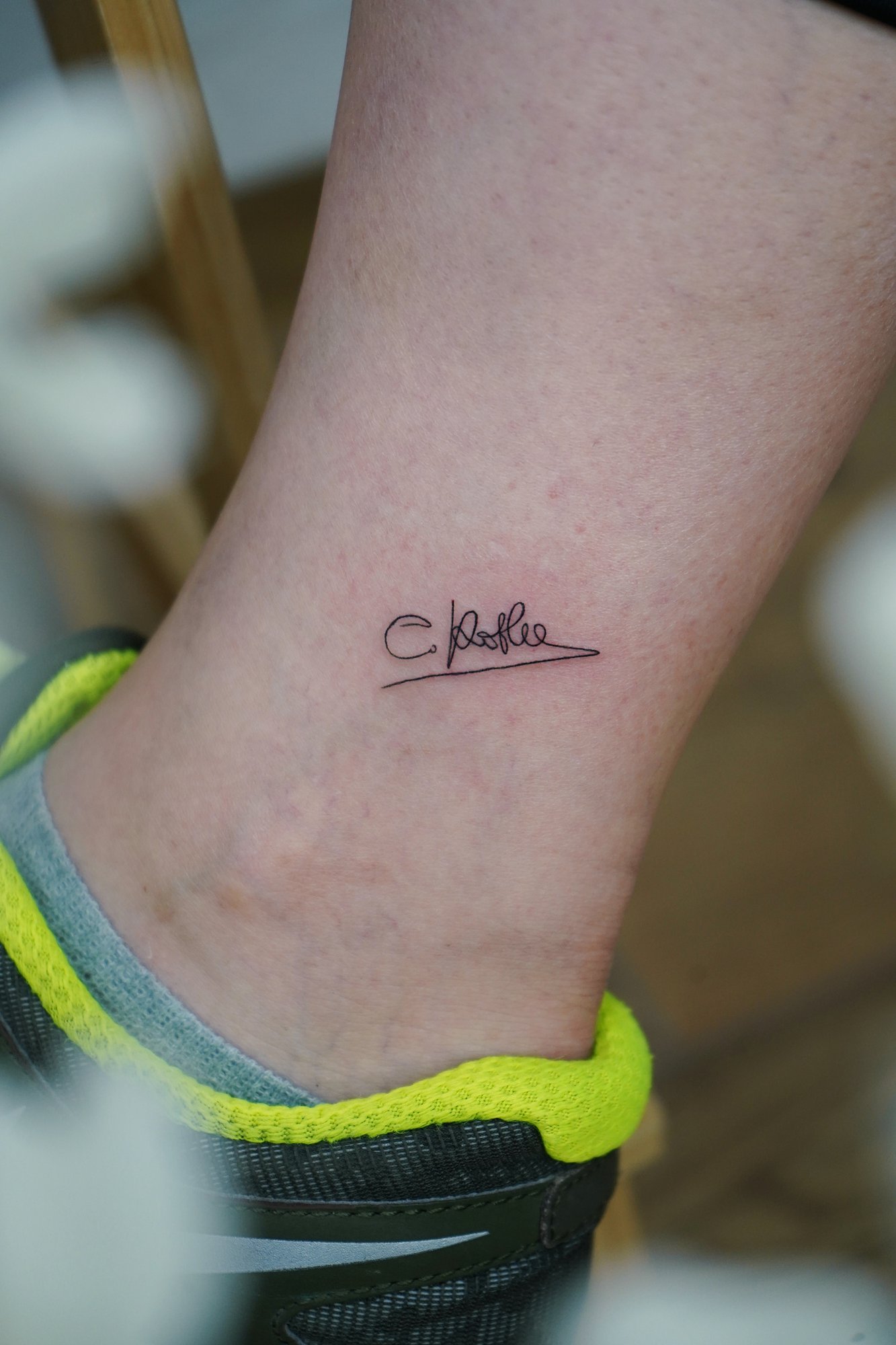 Tatuaje de firma en tobillo, línea fina
