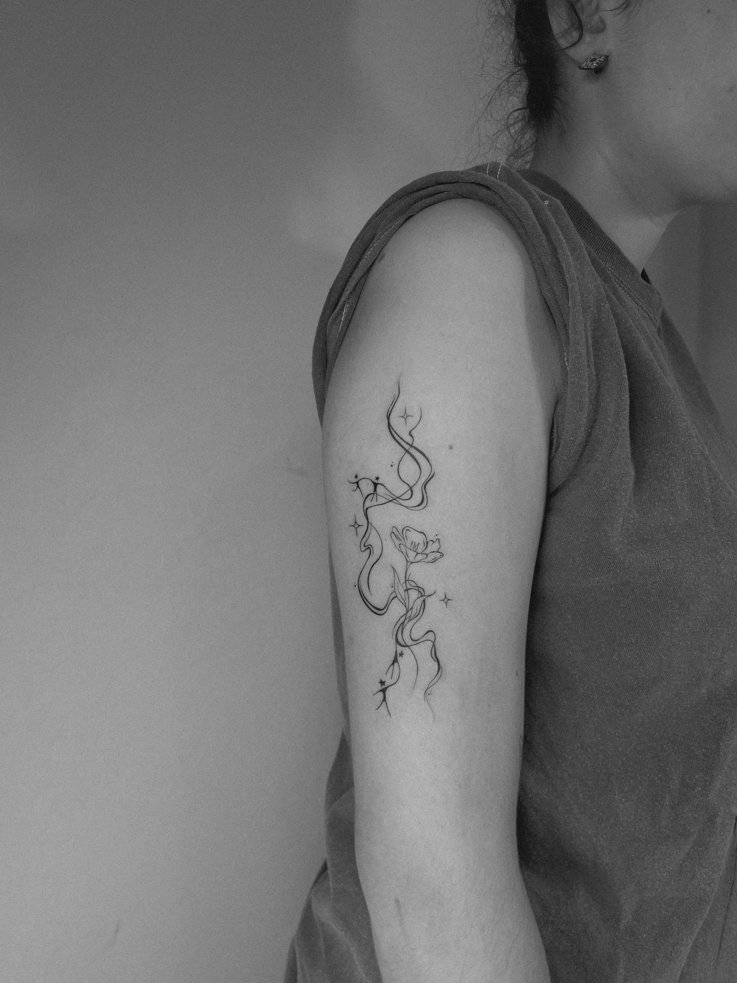 Tatuaje de humo flores monigotes en zona desconocida, línea fina