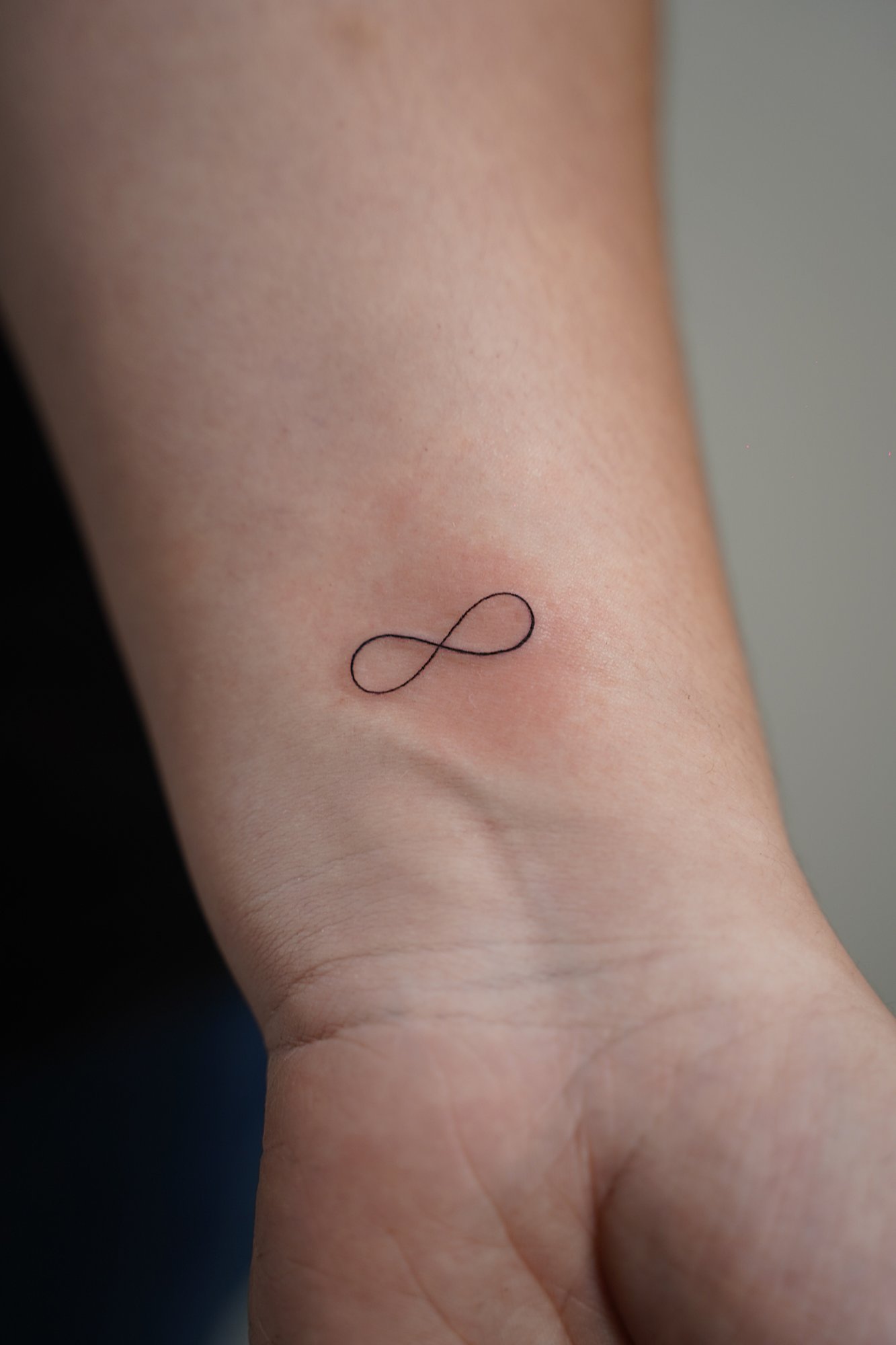 Tatuaje de infinito en zona desconocida, línea fina