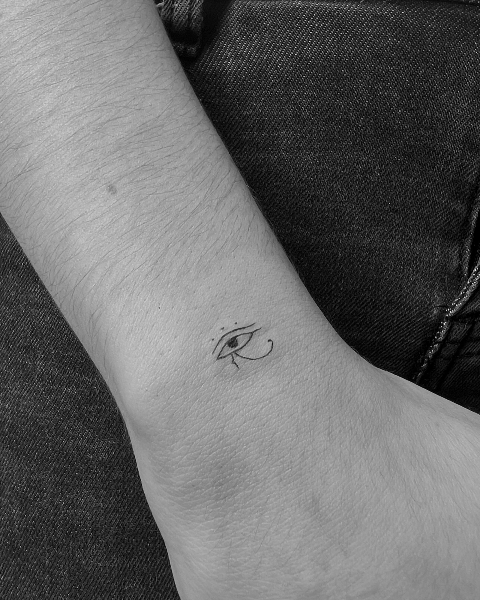 Tatuaje de ojo de horus egipcio en muneca, línea fina