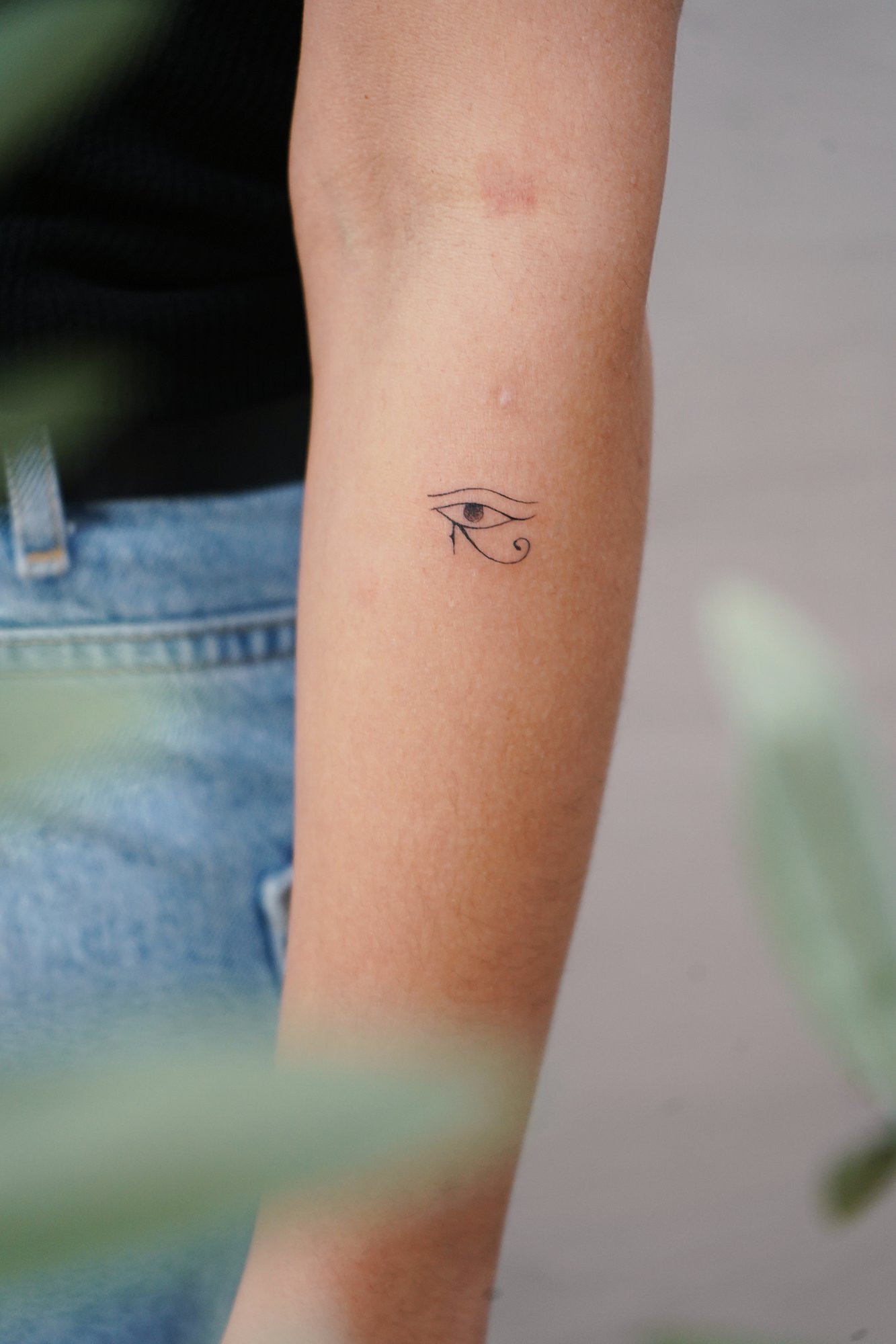 Tatuaje de ojos oro en brazo, línea fina