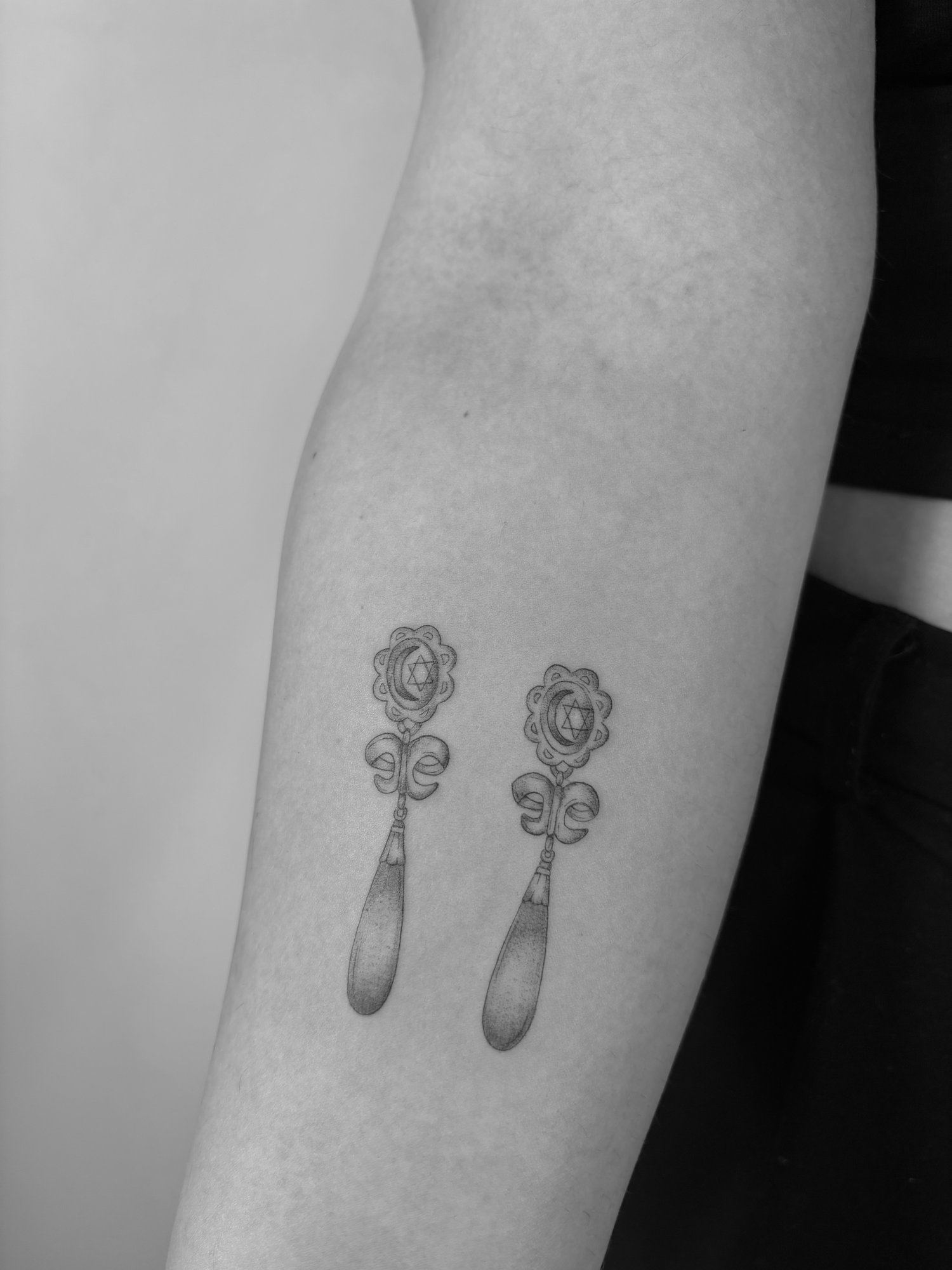 Tatuaje de pendientes joyeria ornamental  en antebrazo, línea fina