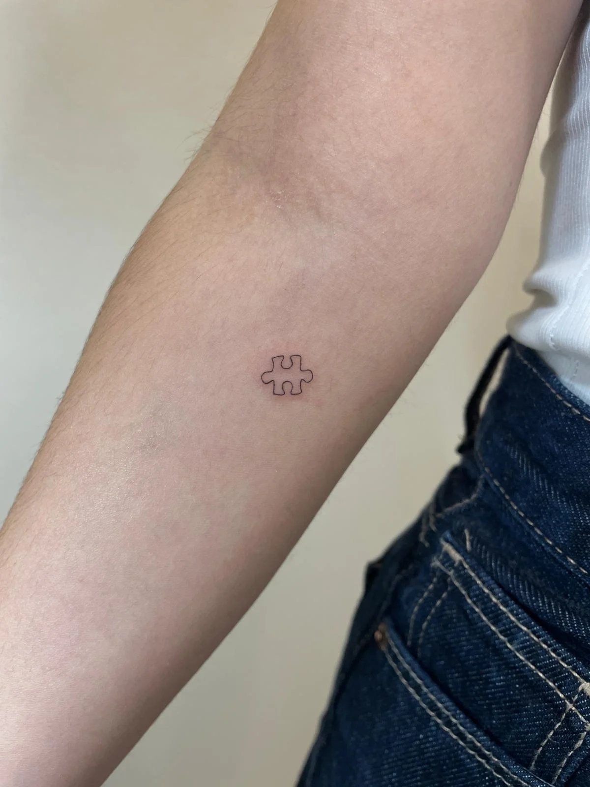 Tatuaje pieza puzzle minimalista antebrazo