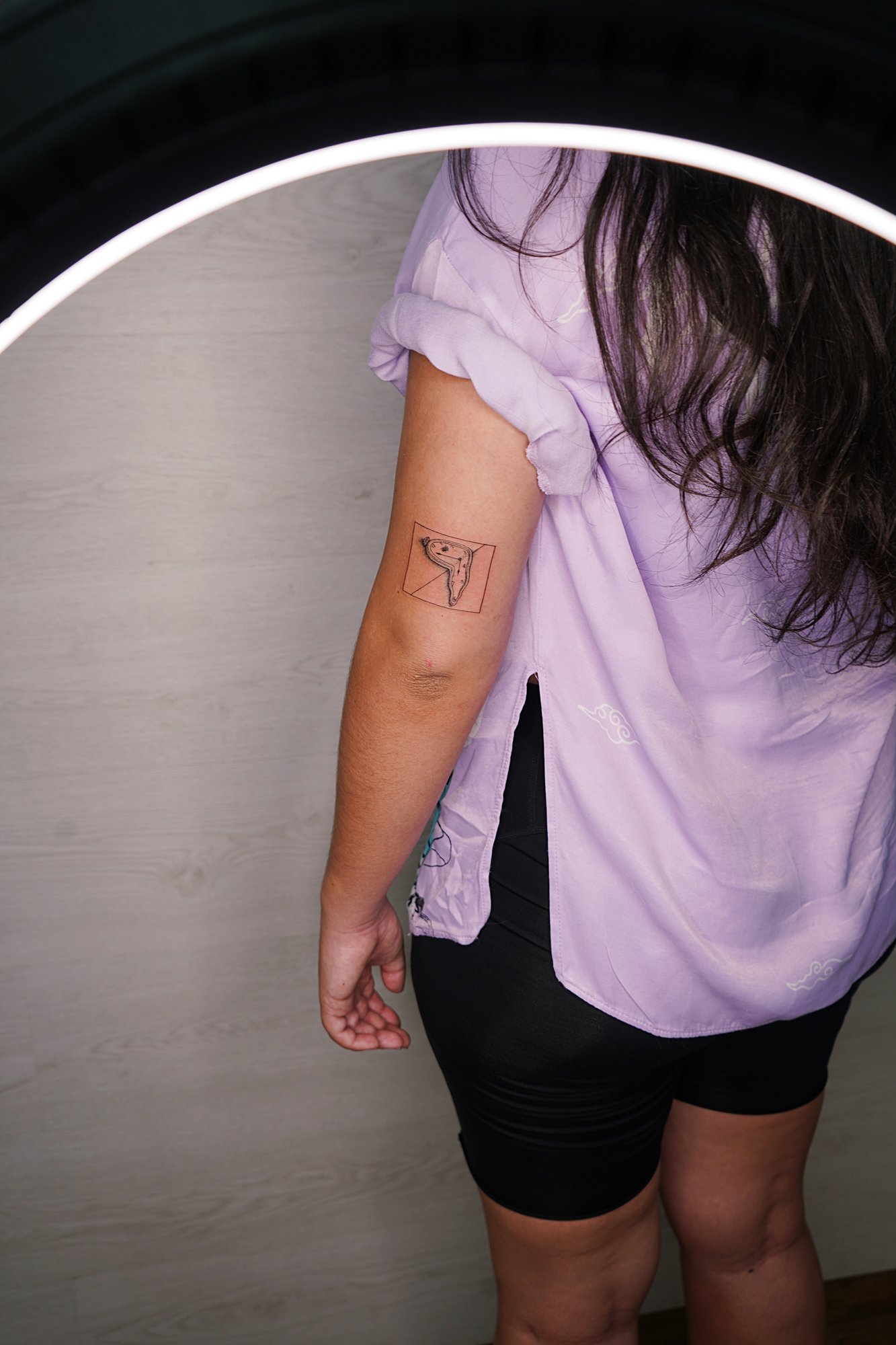 Tatuaje de reloj derretido en codo, línea fina