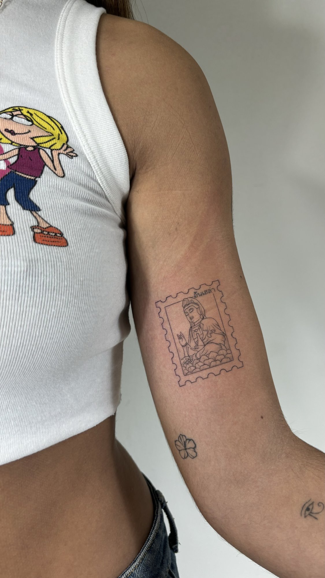 Tatuaje de sello buda en biceps, línea fina