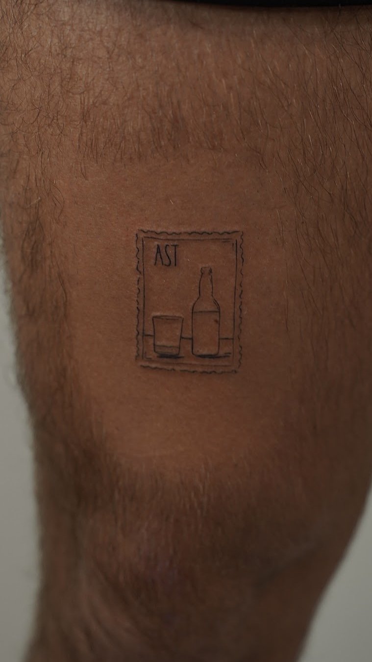 Tatuaje de sello postal botella vaso en muslo, línea fina