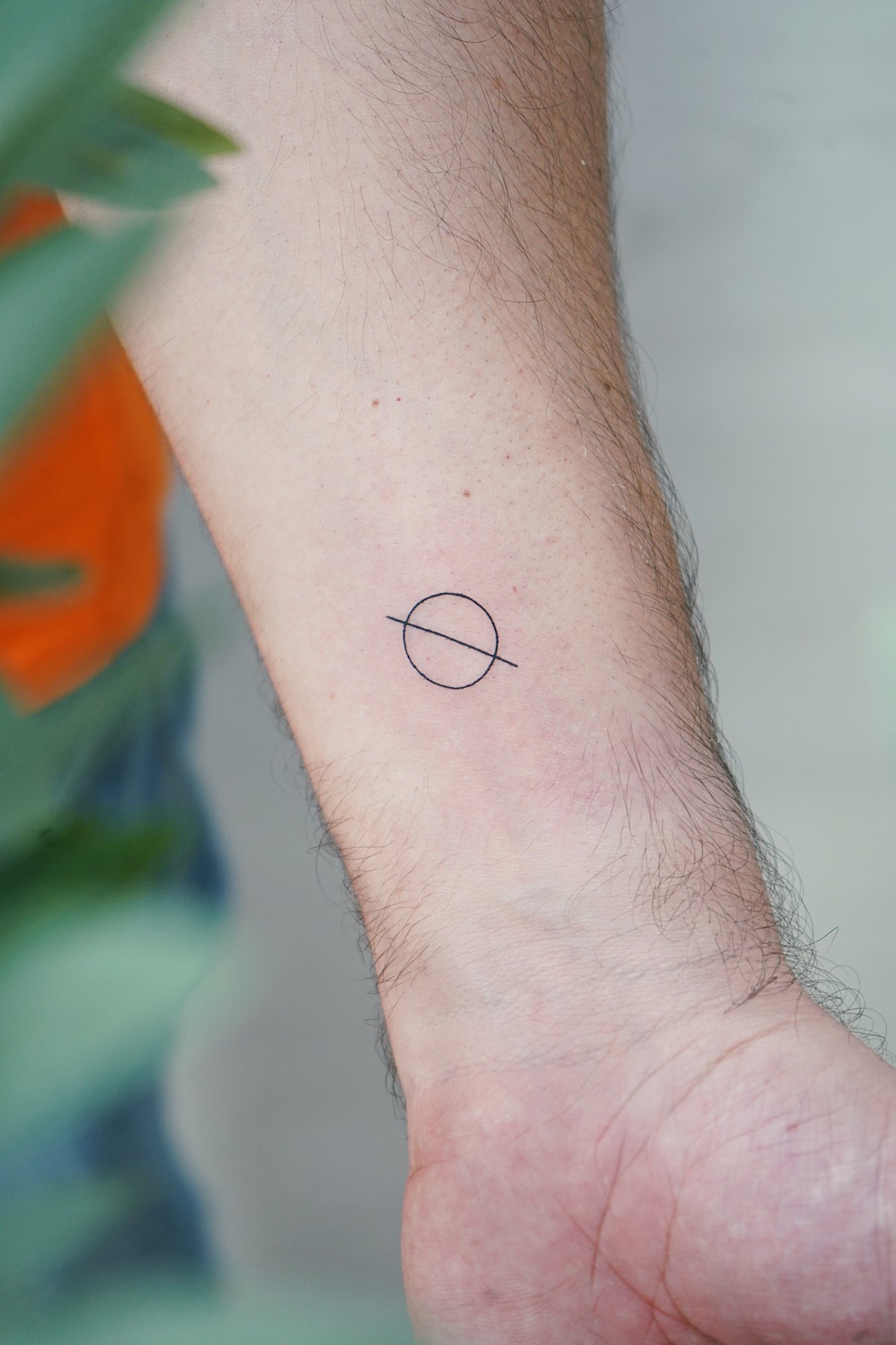 Tatuaje de simbolo en muneca, línea fina