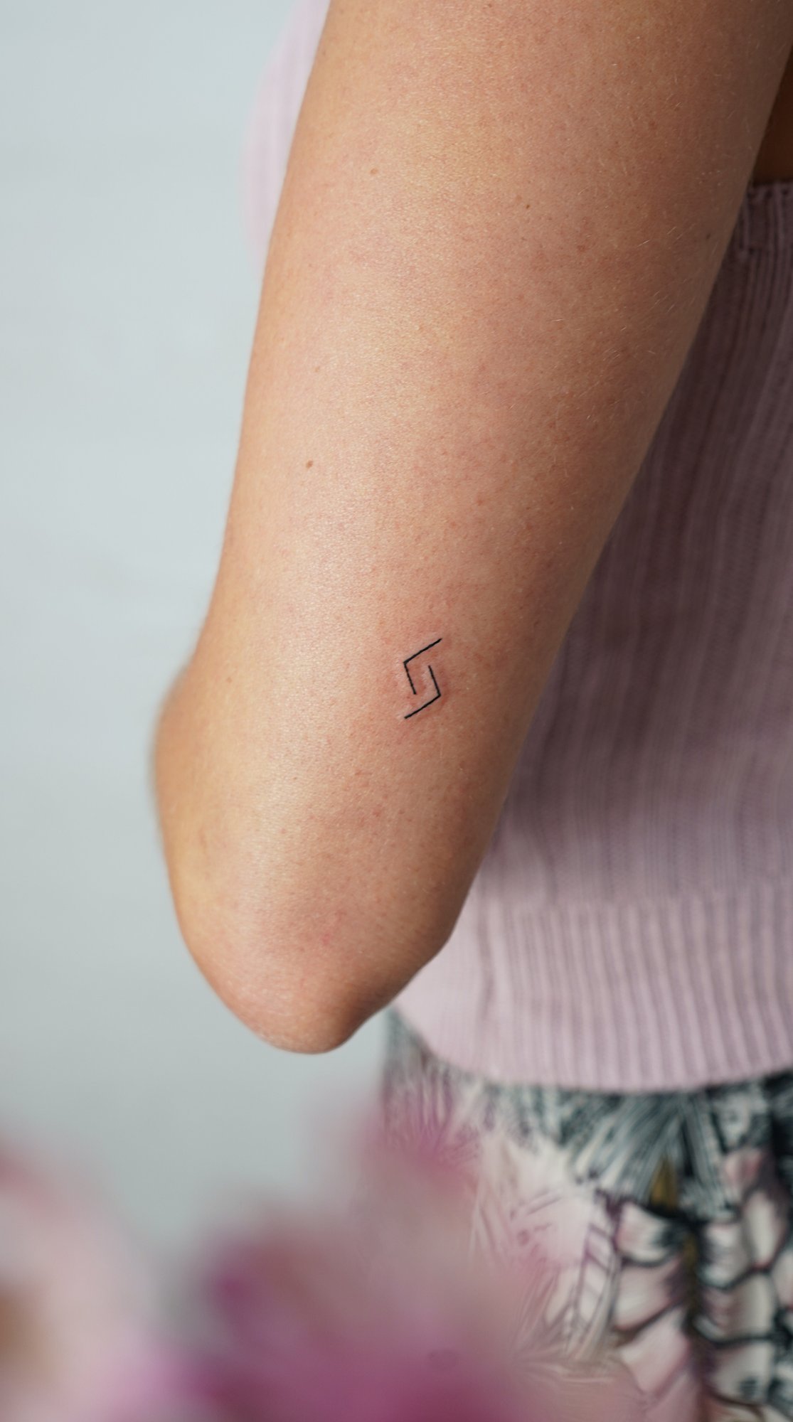 Tatuaje de simbolo en muneca, línea fina