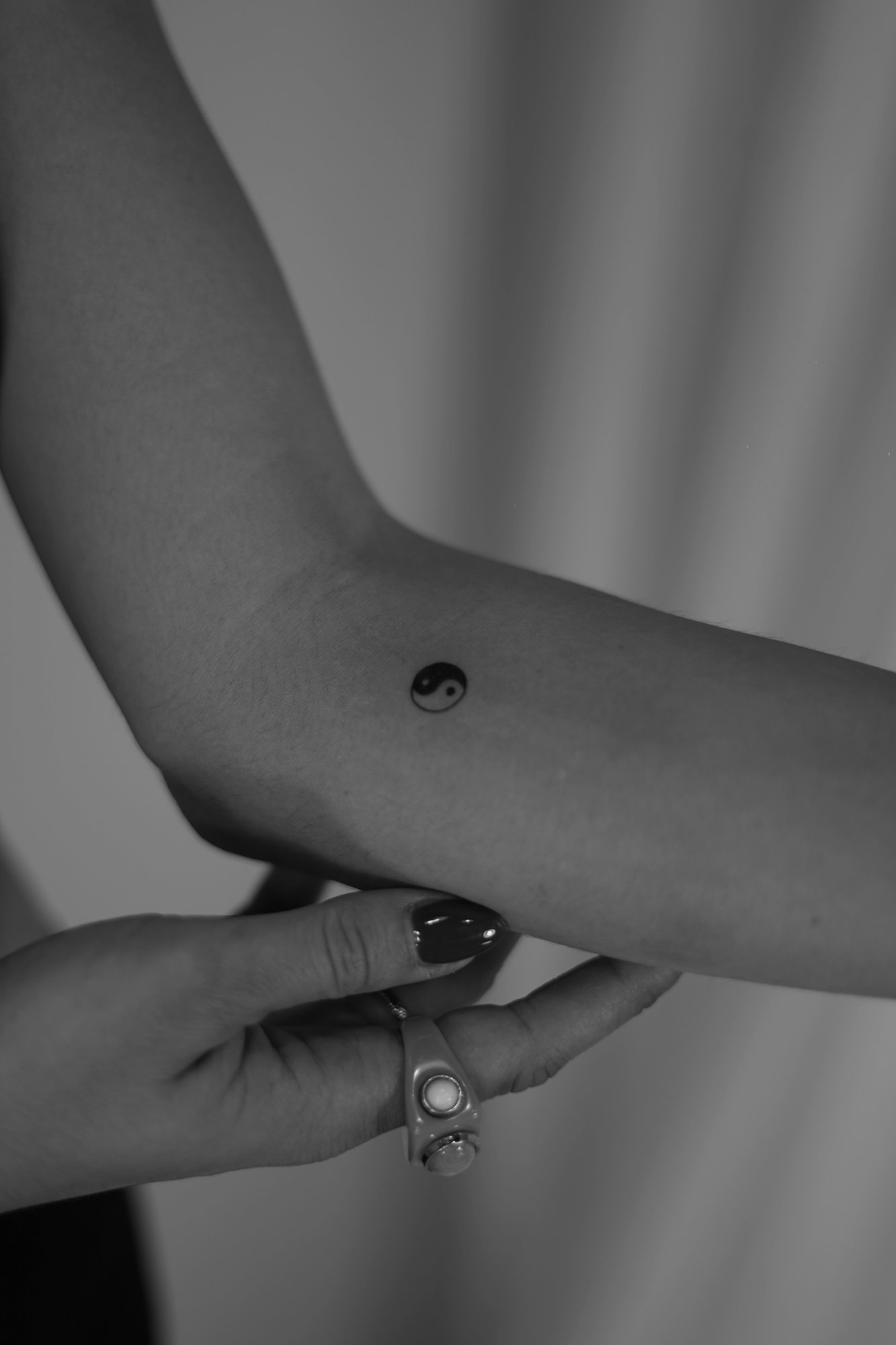 Tatuaje de yin yang simbolo pequeno en muneca, línea fina