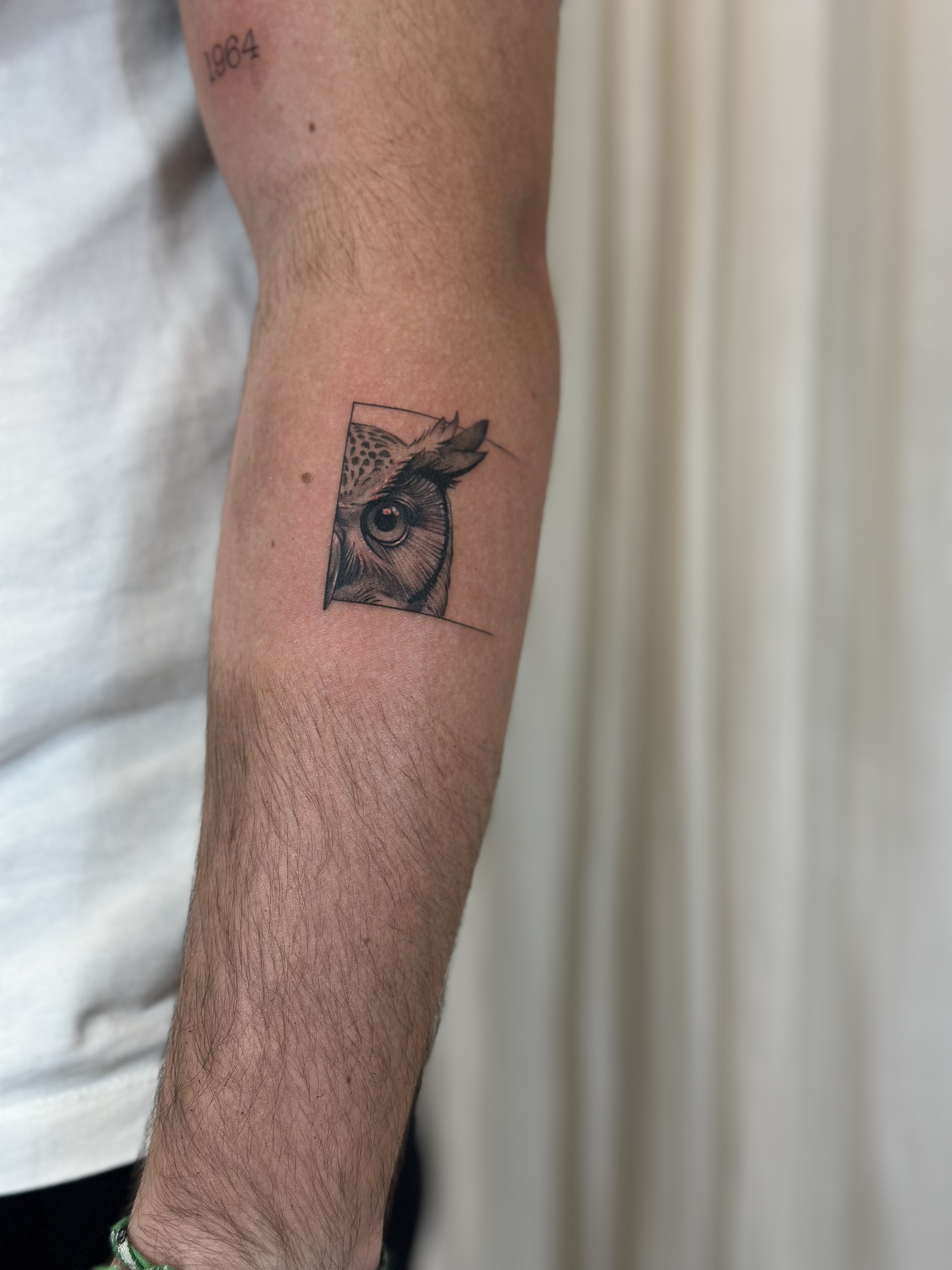 Tatuaje de búho geométrico en antebrazo, línea fina Sinkply Madrid