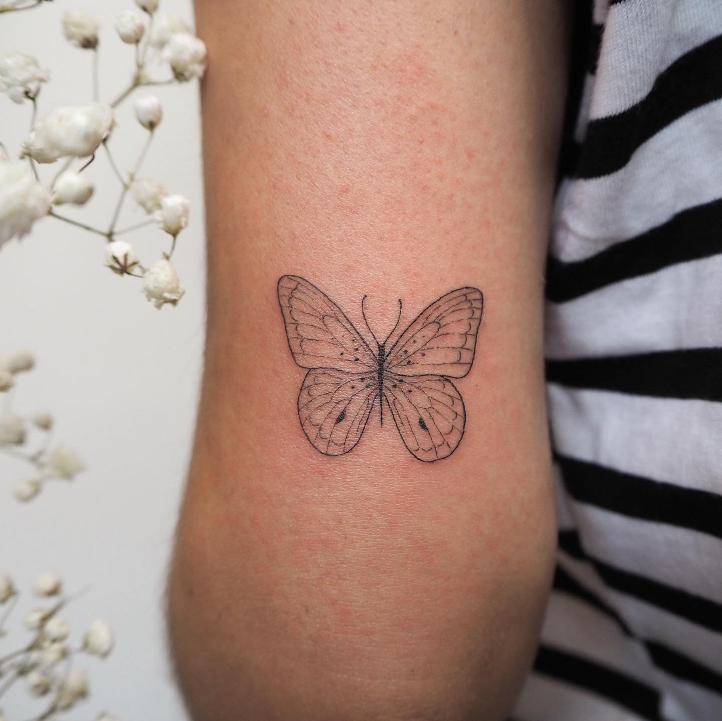 Tatuaje de mariposa en antebrazo, línea fina Sinkply Madrid