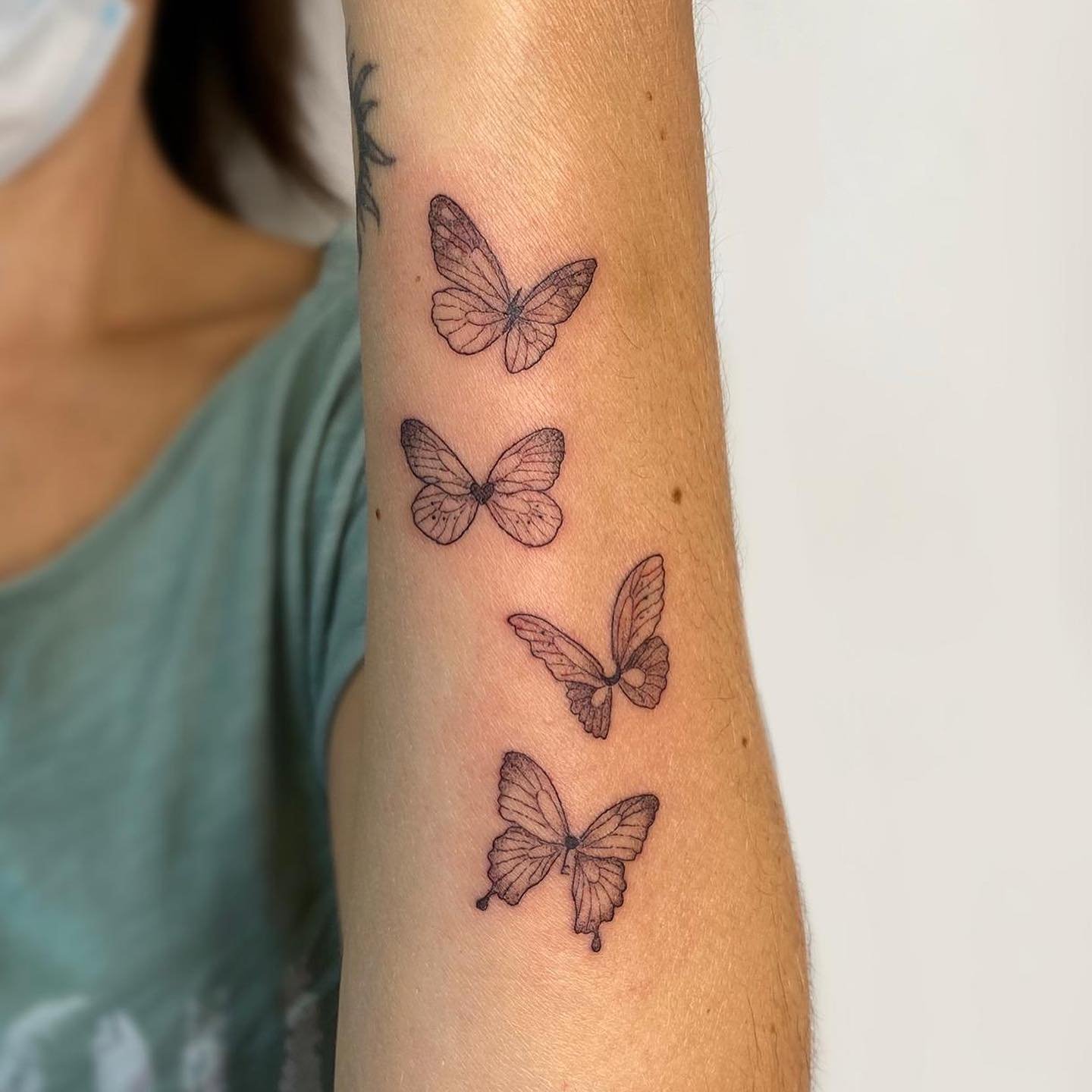 Tatuaje de mariposa en antebrazo, línea fina Sinkply Madrid
