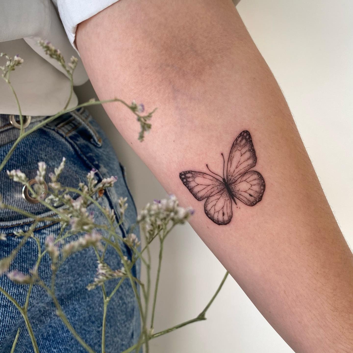 Tatuaje de mariposa en antebrazo, línea fina Sinkply Madrid