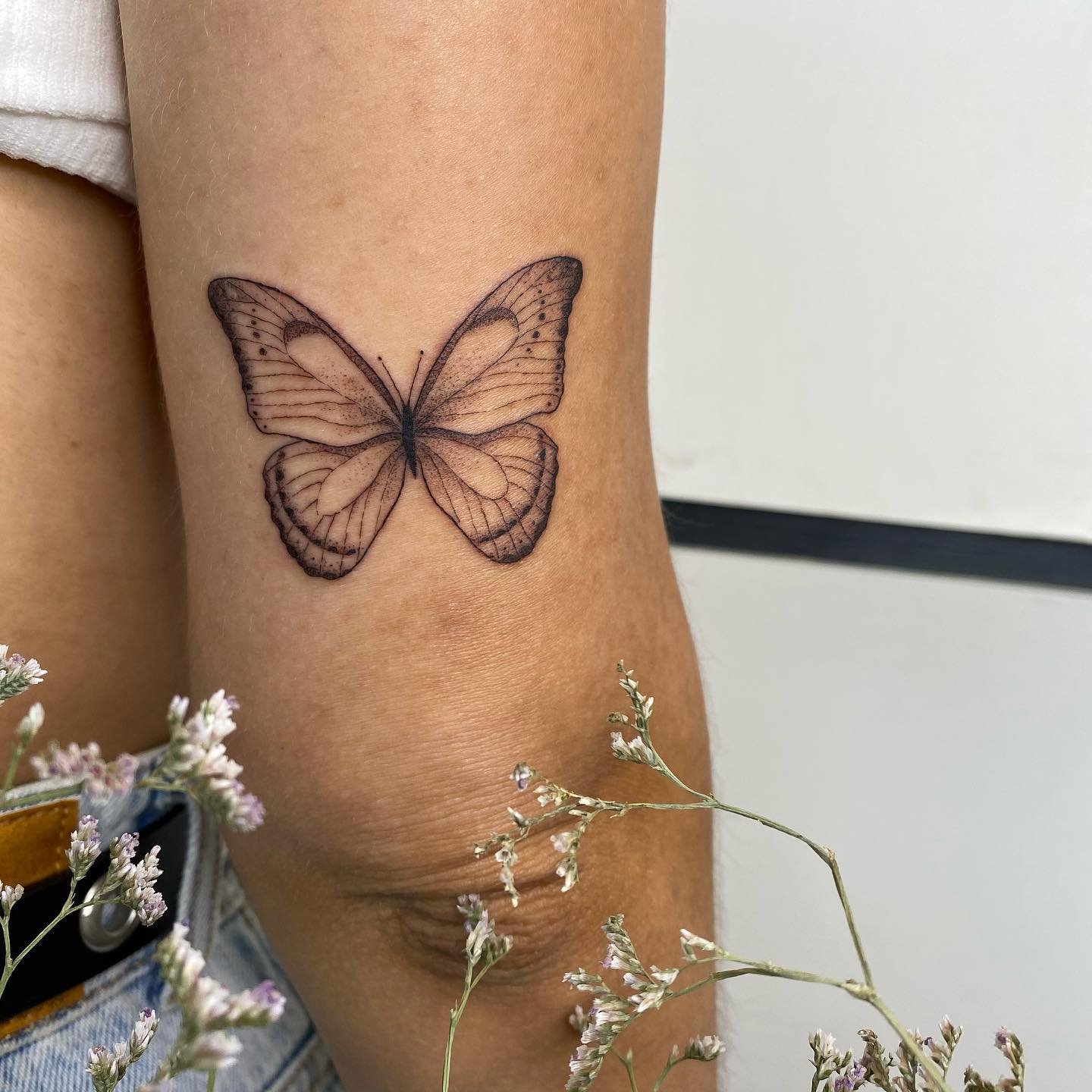 Tatuaje de mariposa en antebrazo, línea fina Sinkply Madrid