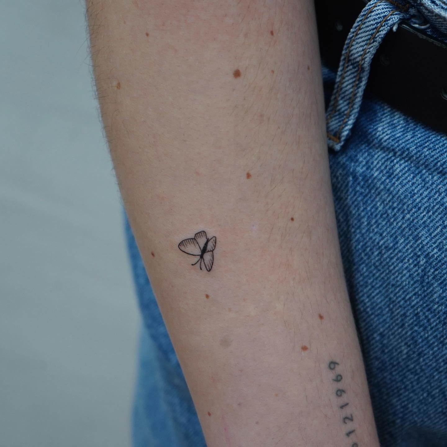 Tatuaje de mariposa en antebrazo, línea fina Sinkply Madrid