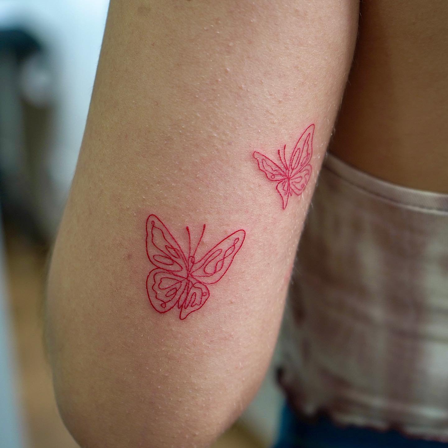 Tatuaje de mariposa en antebrazo, línea fina Sinkply Madrid