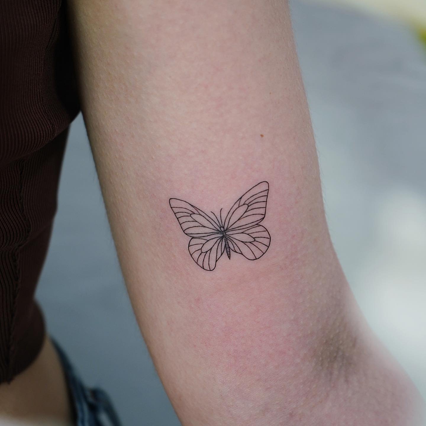 Tatuaje de mariposa en antebrazo, línea fina Sinkply Madrid