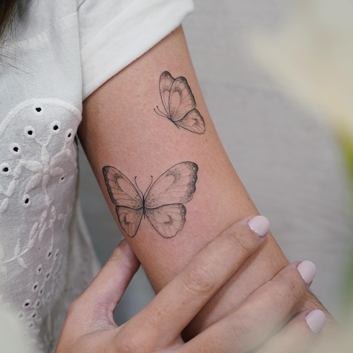 Tatuaje de mariposa en antebrazo, línea fina Sinkply Madrid