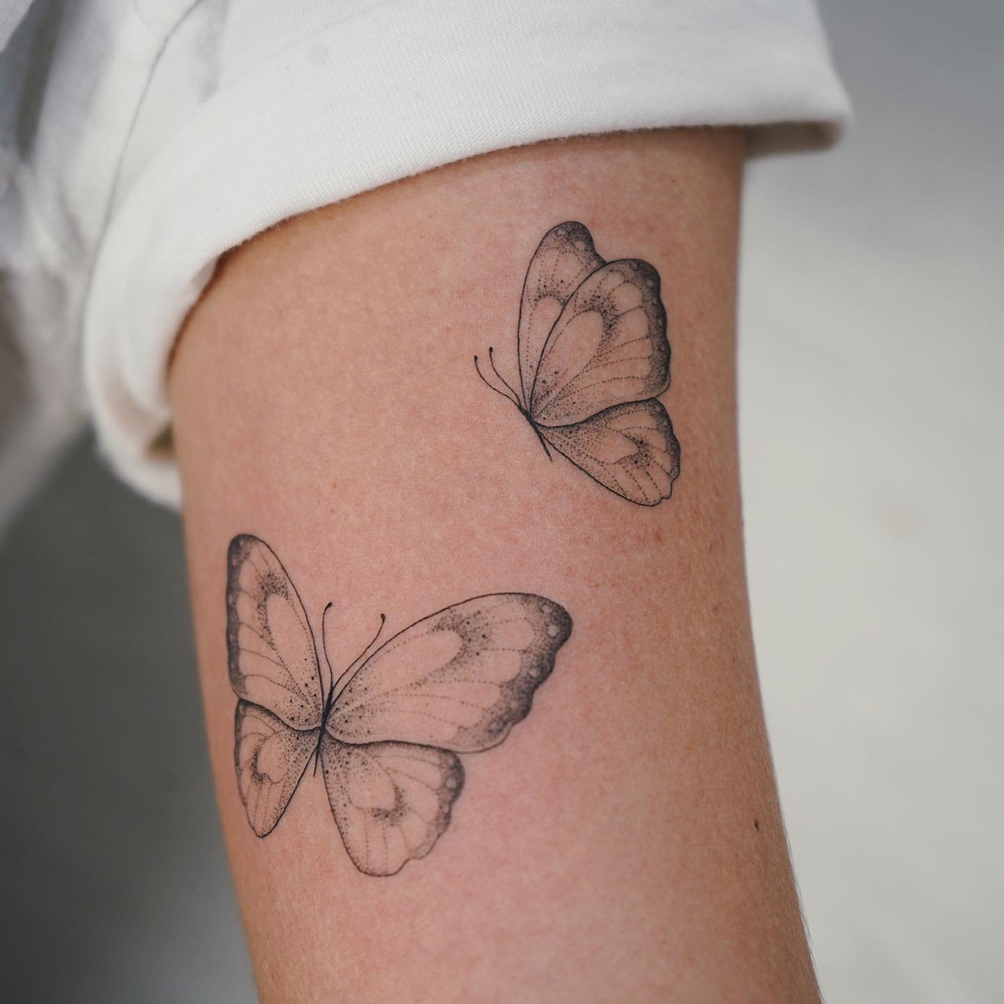 Tatuaje de mariposa en antebrazo, línea fina Sinkply Madrid