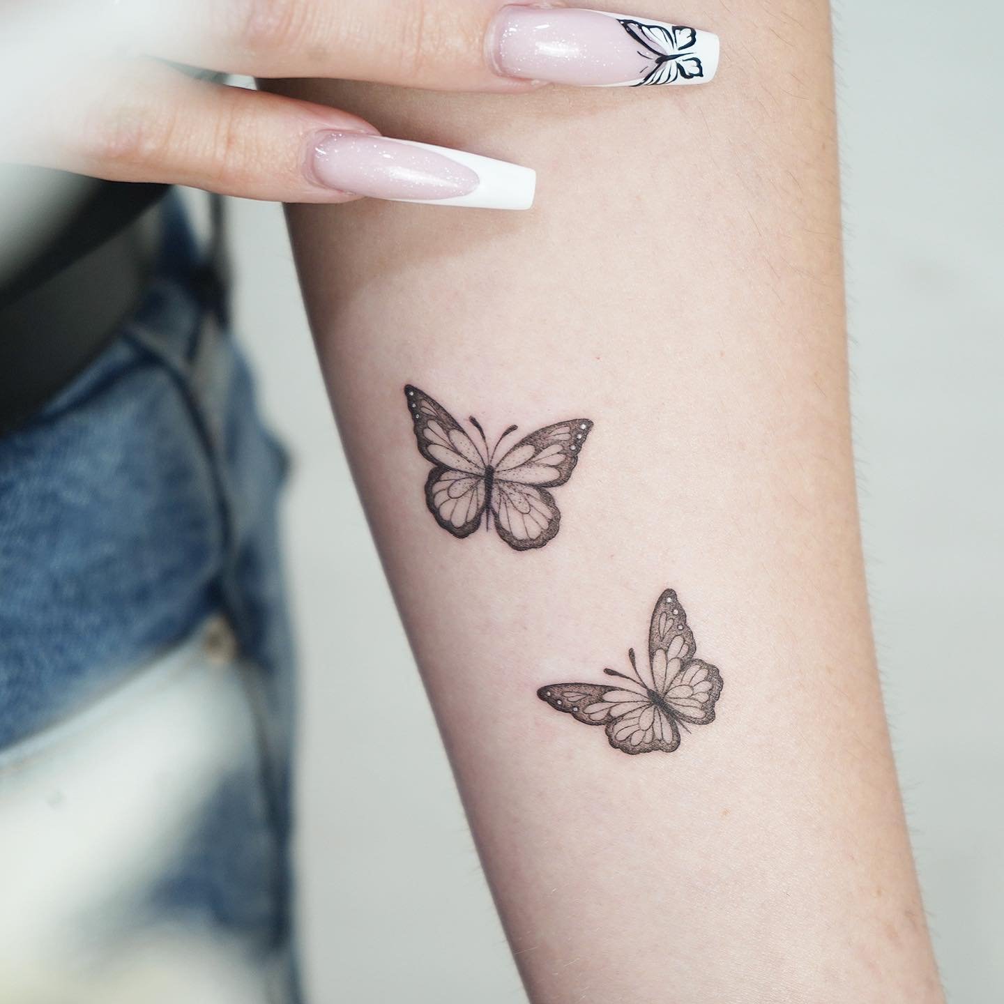 Tatuaje de mariposa en antebrazo, línea fina Sinkply Madrid