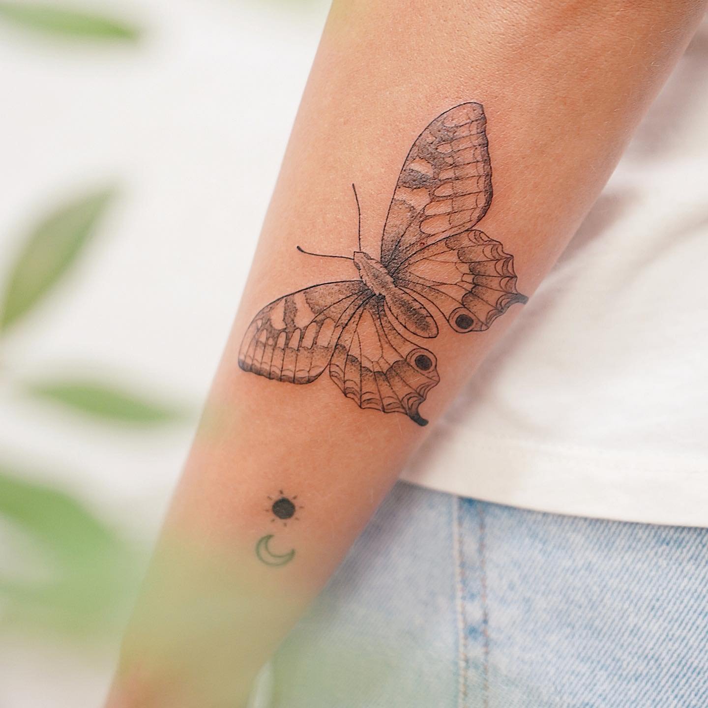 Tatuaje de mariposa en antebrazo, línea fina Sinkply Madrid