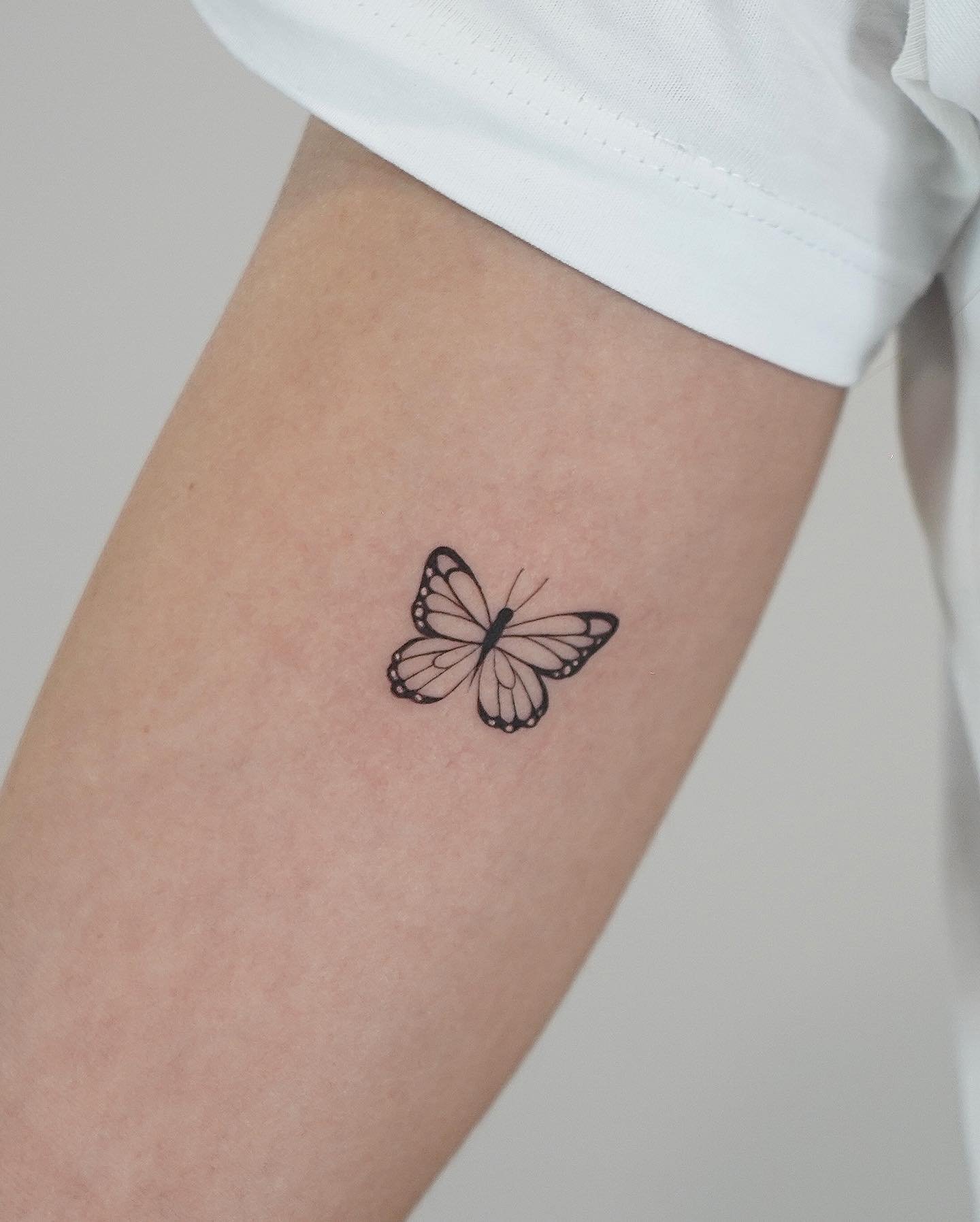 Tatuaje de mariposa en antebrazo, línea fina Sinkply Madrid