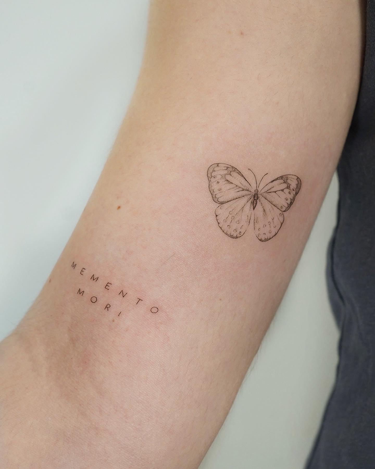 Tatuaje de mariposa en antebrazo, línea fina Sinkply Madrid