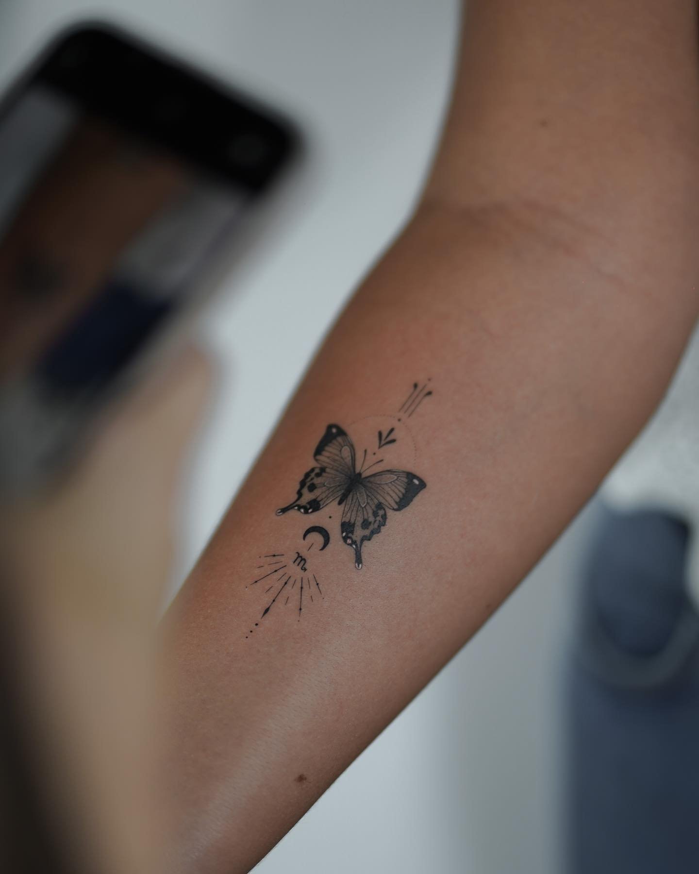 Tatuaje de mariposa en antebrazo, línea fina Sinkply Madrid