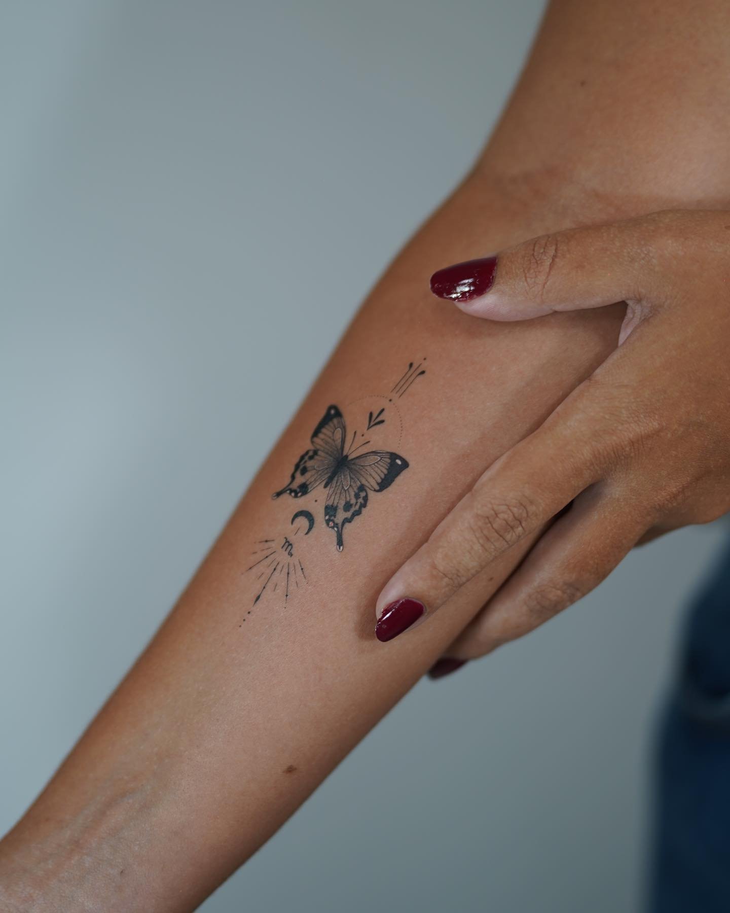 Tatuaje de mariposa en antebrazo, línea fina Sinkply Madrid