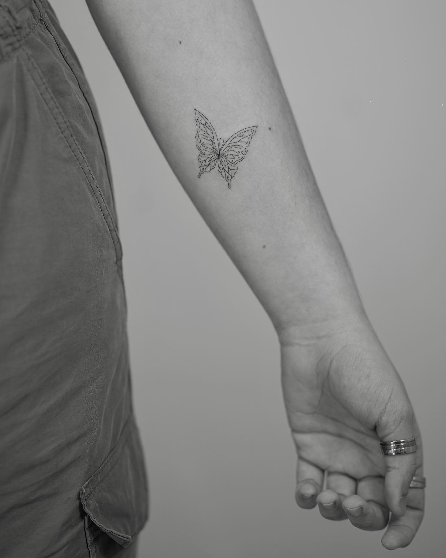 Tatuaje de mariposa en antebrazo, línea fina Sinkply Madrid