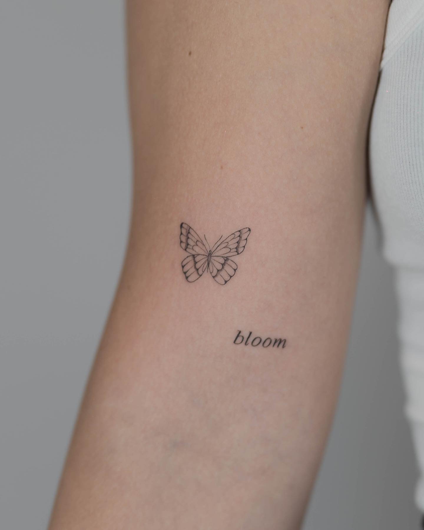 Tatuaje de mariposa en antebrazo, línea fina Sinkply Madrid