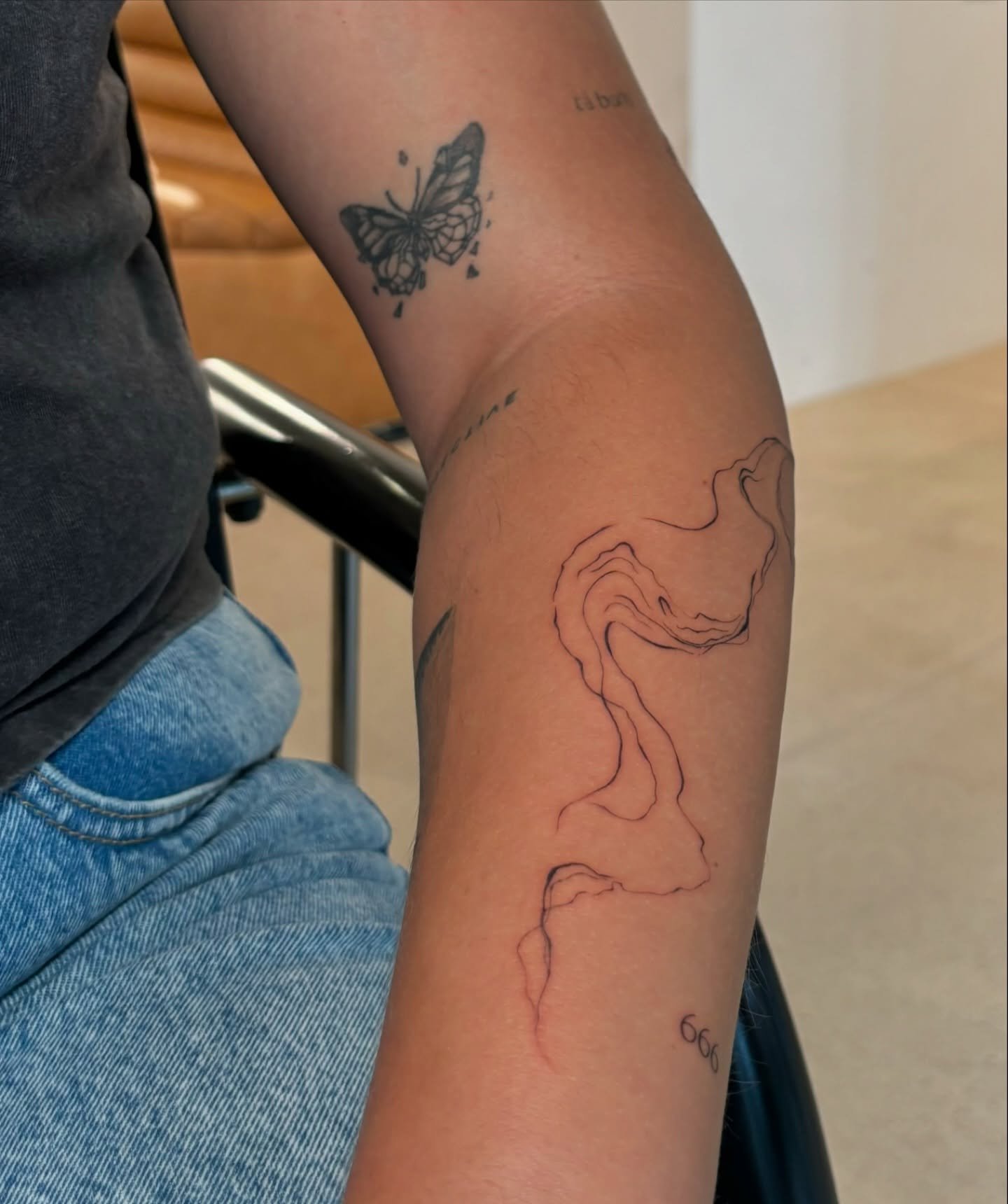 Tatuaje de mariposa en antebrazo, línea fina Sinkply Madrid