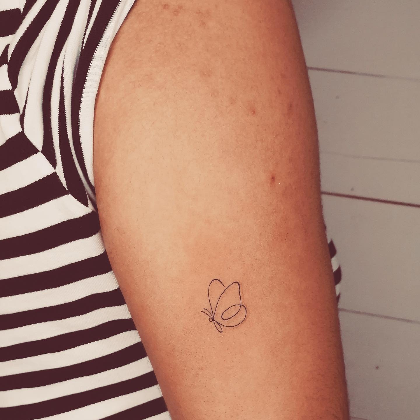 Tatuaje de mariposa en antebrazo, línea fina Sinkply Madrid