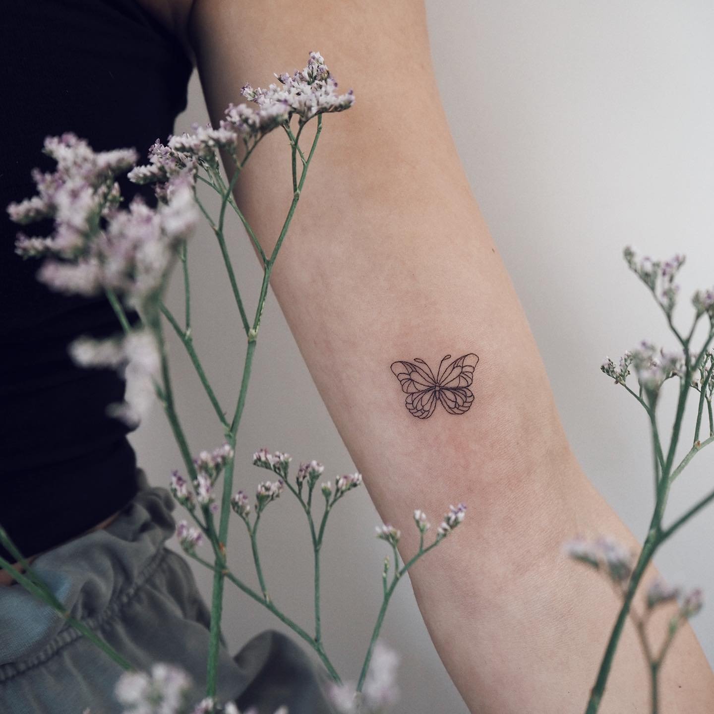 Tatuaje de mariposa en antebrazo, línea fina Sinkply Madrid
