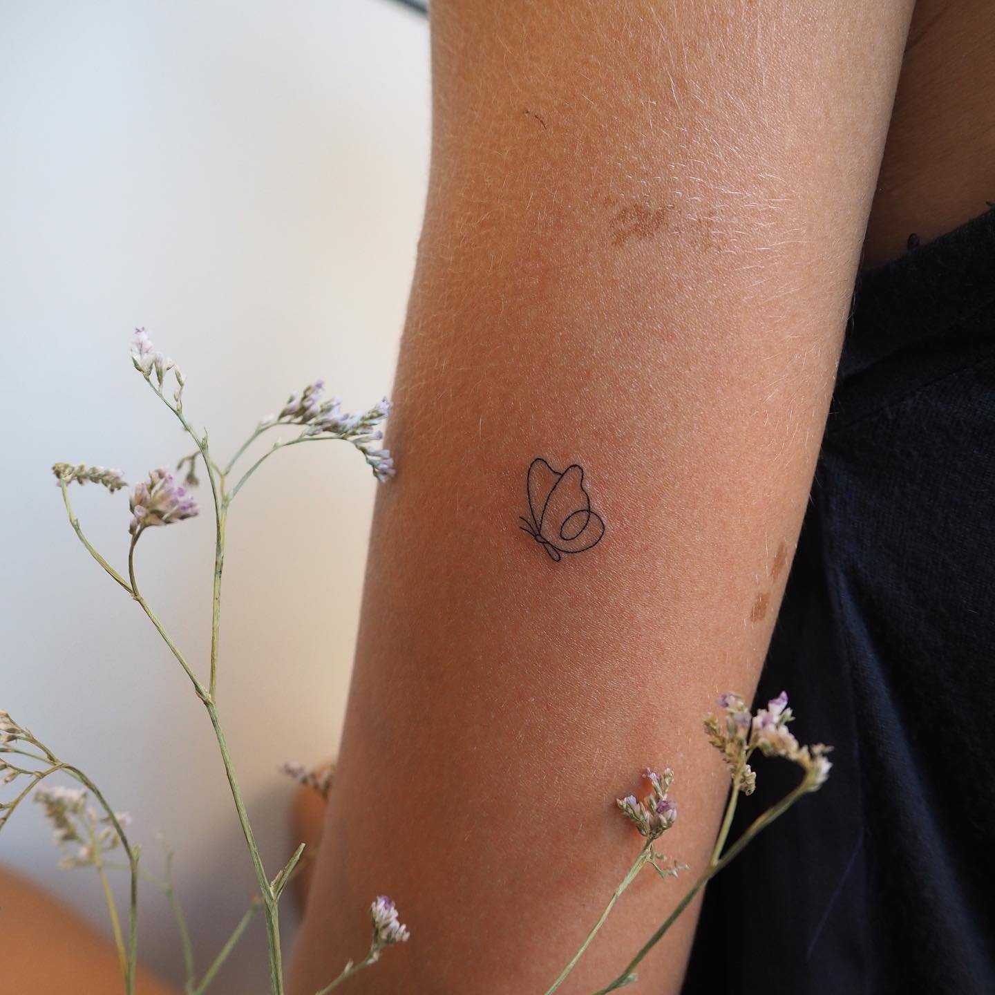 Tatuaje de mariposa en antebrazo, línea fina Sinkply Madrid