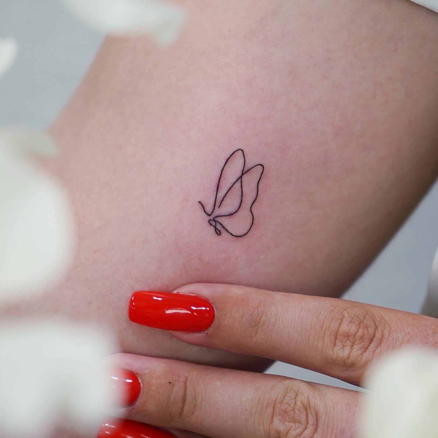 Tatuaje de mariposa en antebrazo, línea fina Sinkply Madrid