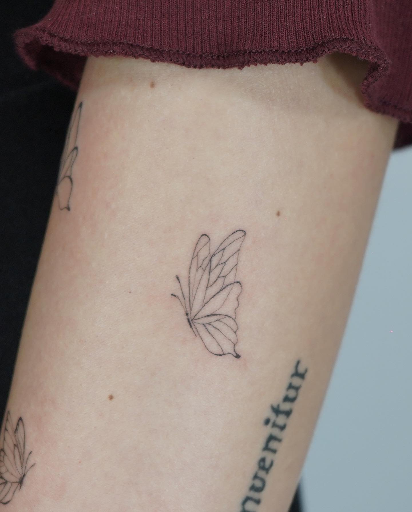 Tatuaje de mariposa en antebrazo, línea fina Sinkply Madrid