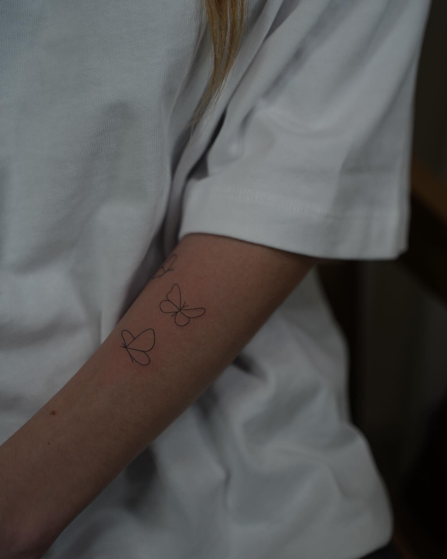 Tatuaje de mariposa en antebrazo, línea fina Sinkply Madrid