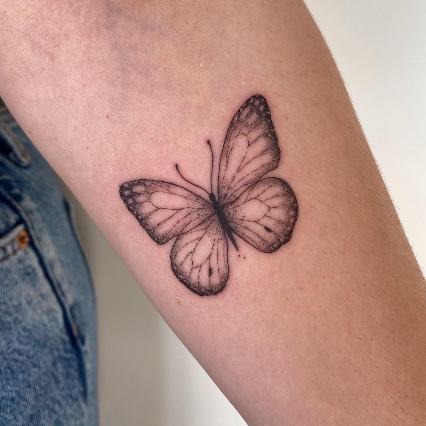 Tatuaje de mariposa en brazo, línea fina Sinkply Madrid
