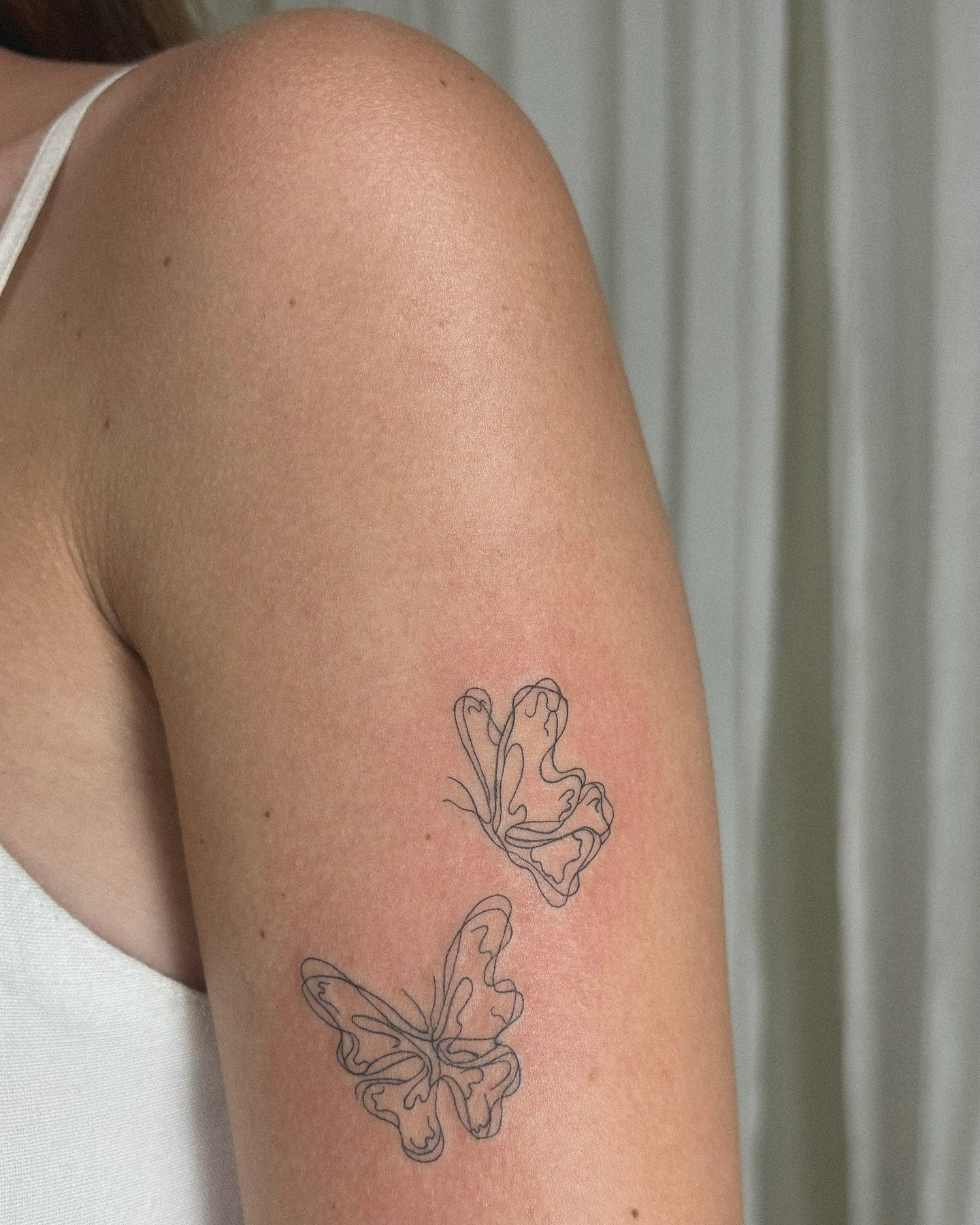 Tatuaje de mariposa en brazo, línea fina Sinkply Madrid