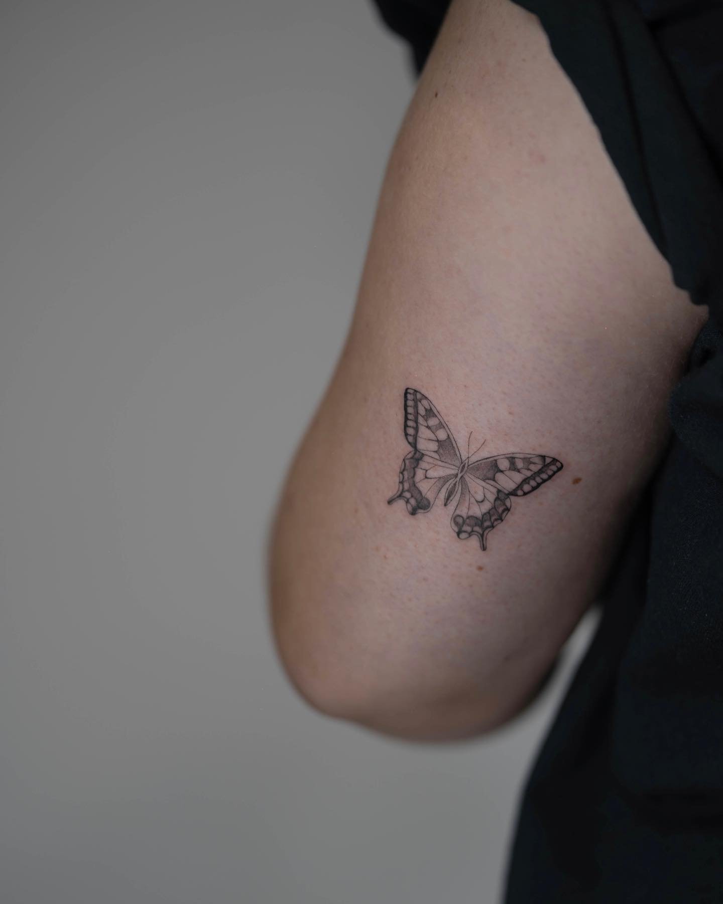 Tatuaje de mariposa en muslo, línea fina Sinkply Madrid