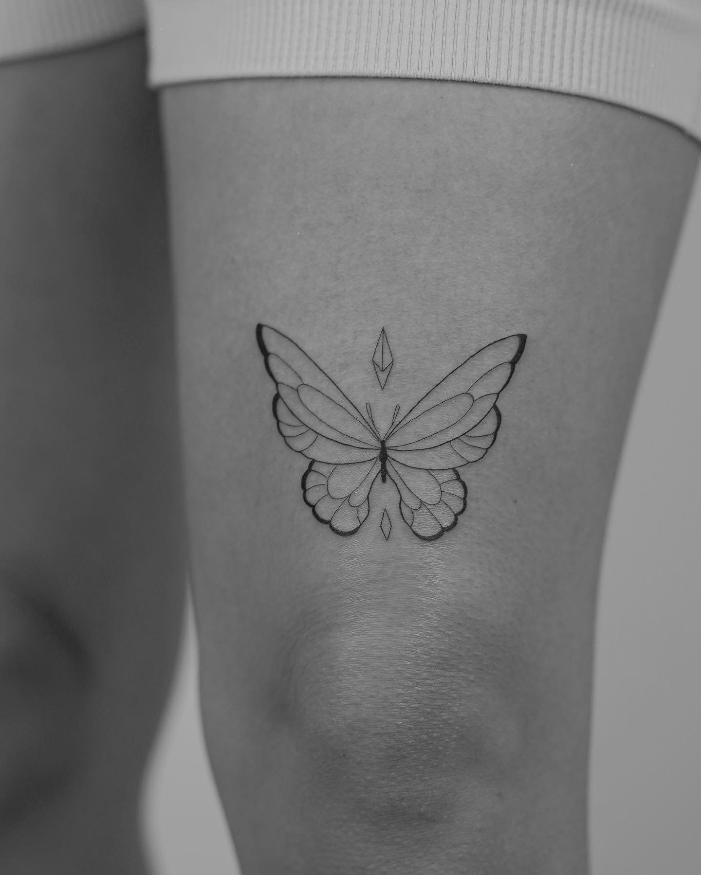 Tatuaje de mariposa en muslo, línea fina Sinkply Madrid
