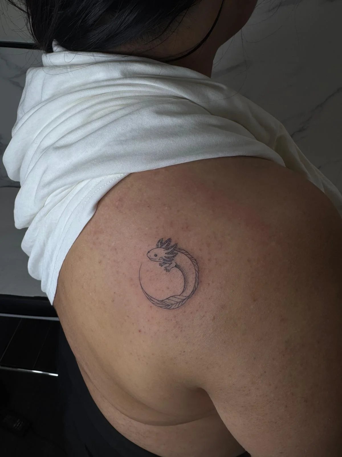 Tatuaje animales axolotl circular minimalista costillas