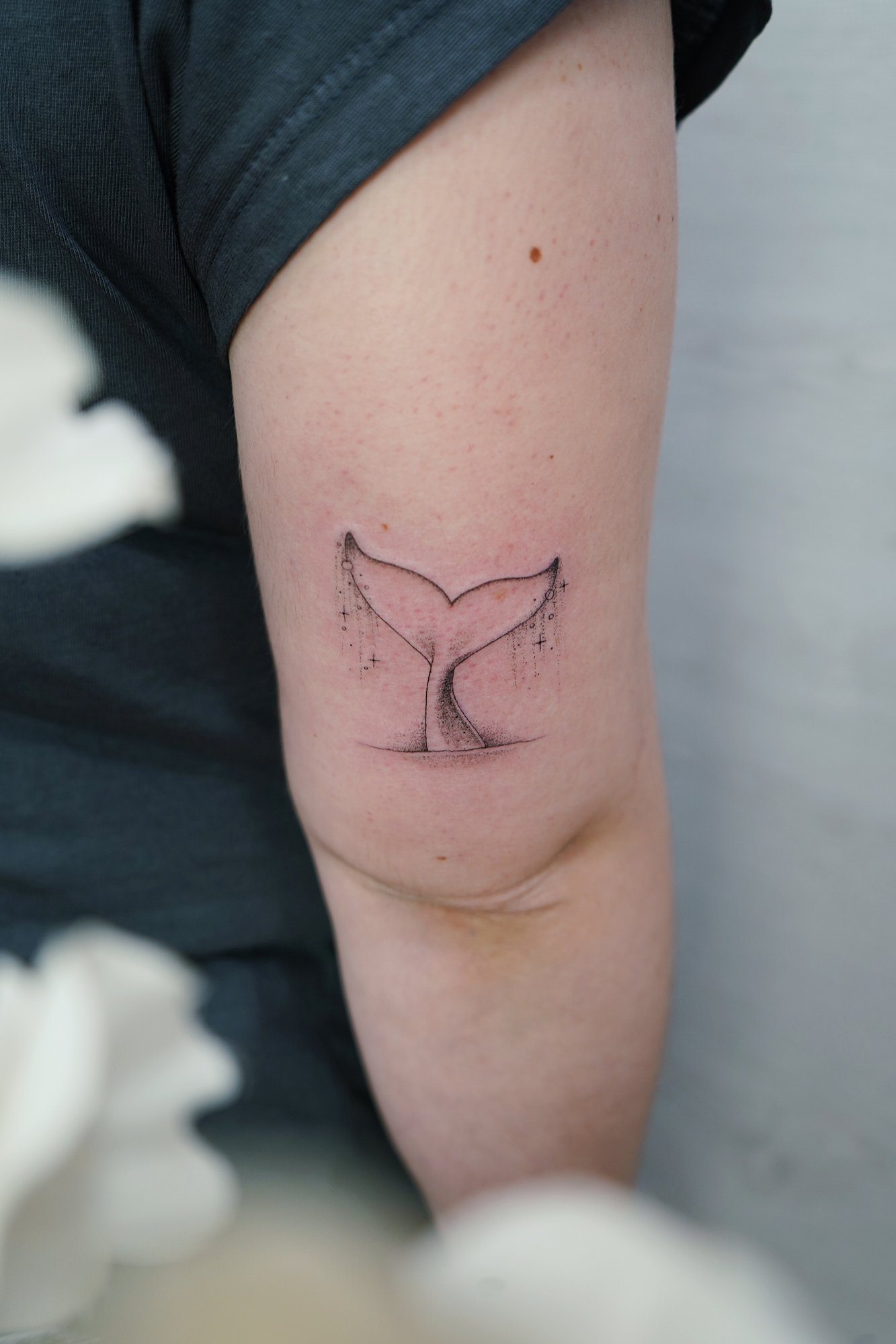 Tatuaje de cola ballena en codo, línea fina